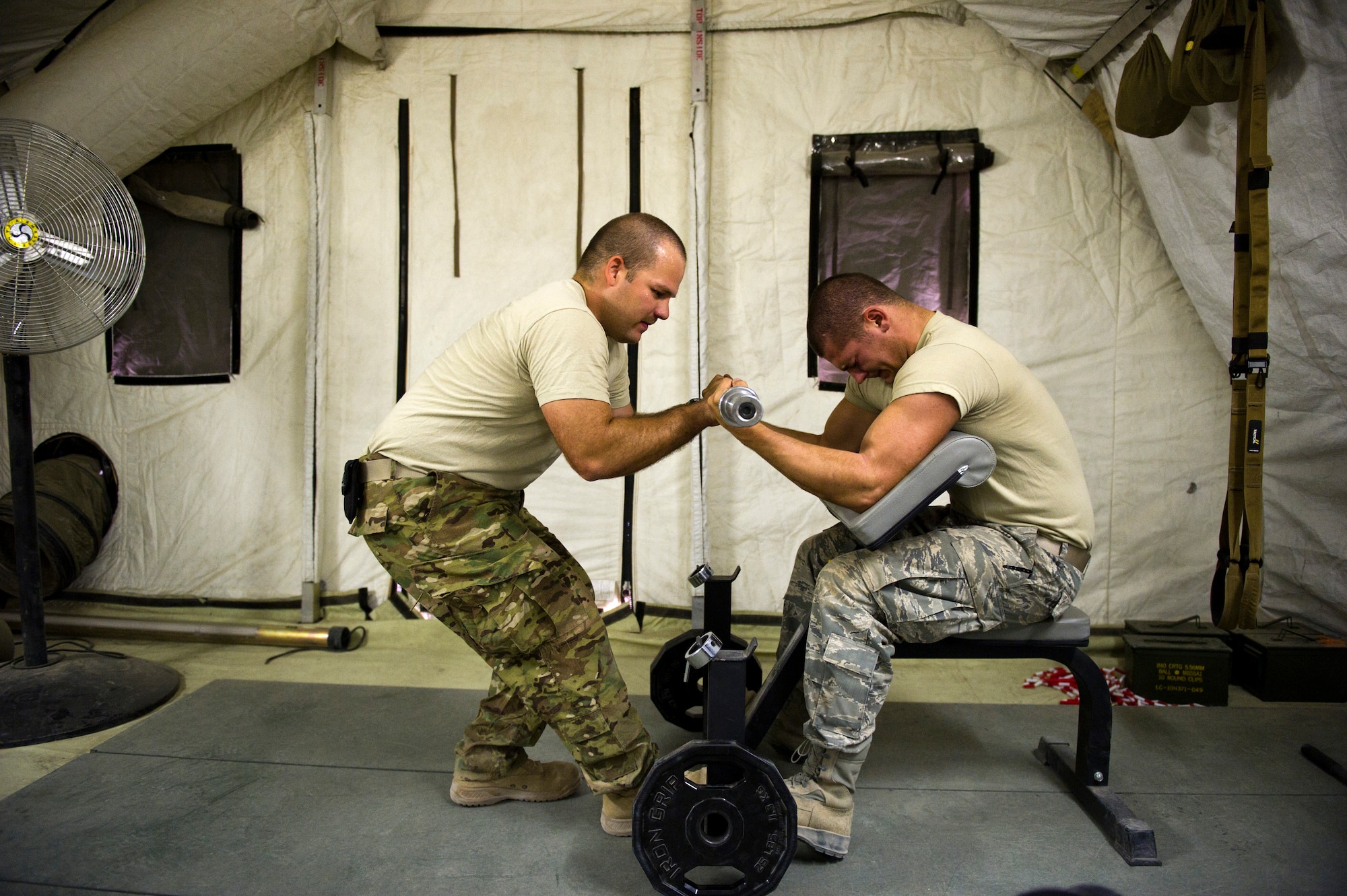 Airmen 1st Class Bryant Horton (left) and Travis Williams, Detachment 1, 73rd Expeditionary Air Control Squadron, use the small gym at Camp Etchberger to work out. An emphasis is placed on fitness in the camp and Airmen find various ways to stay in shape. (U.S. Air Force Photo/Master Sgt. Jeffrey Allen)