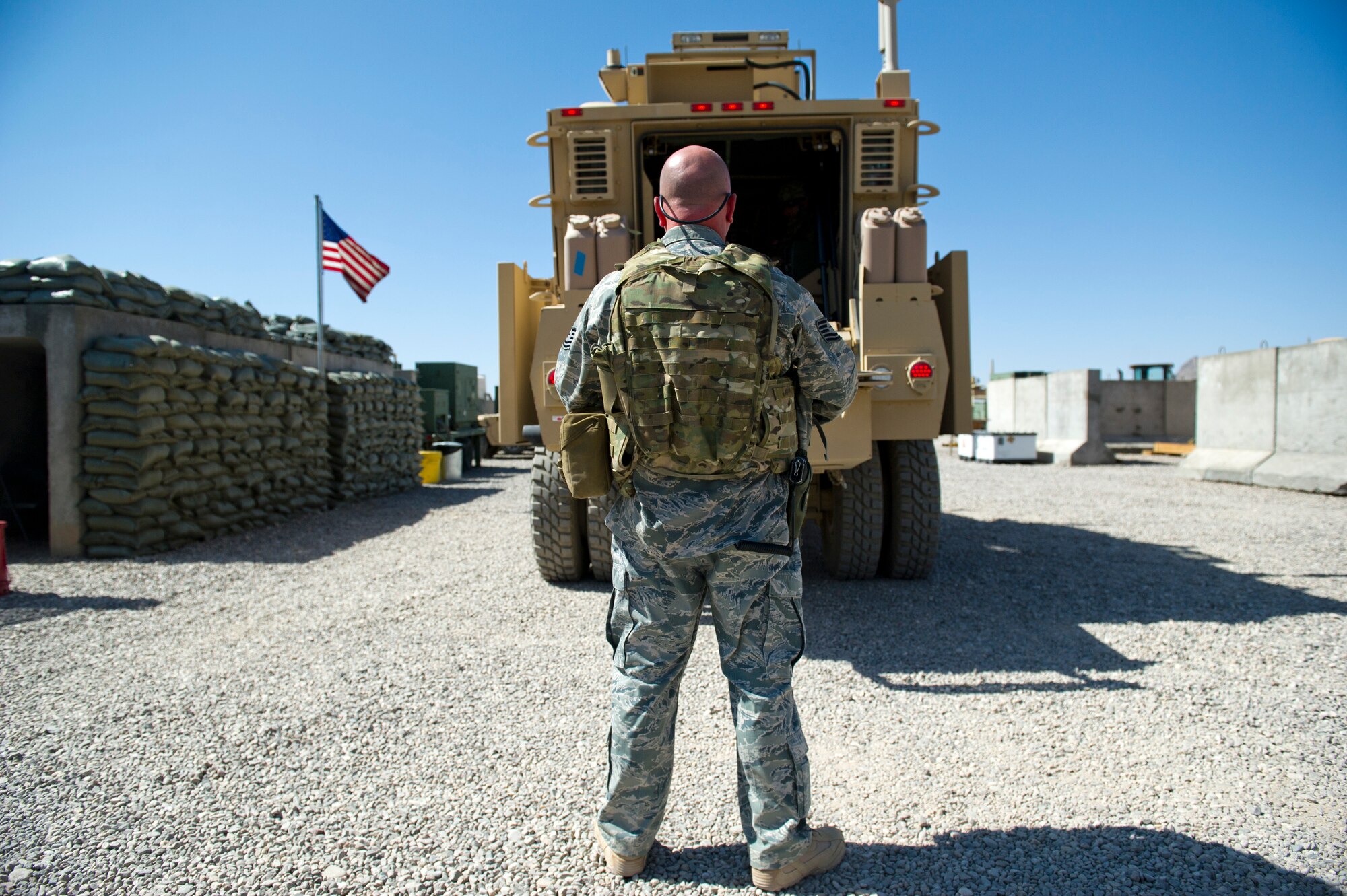 Tech. Sgt. Todd Lavender, Detachment 1, 73rd Expeditionary Air Control Squadron, makes sure the area behind the mine resistant ambush protected vehicle remains clear while the back door is opened. The Airmen use the MRAP as their primary convoy vehicle. (U.S. Air Force Photo/Master Sgt. Jeffrey Allen)