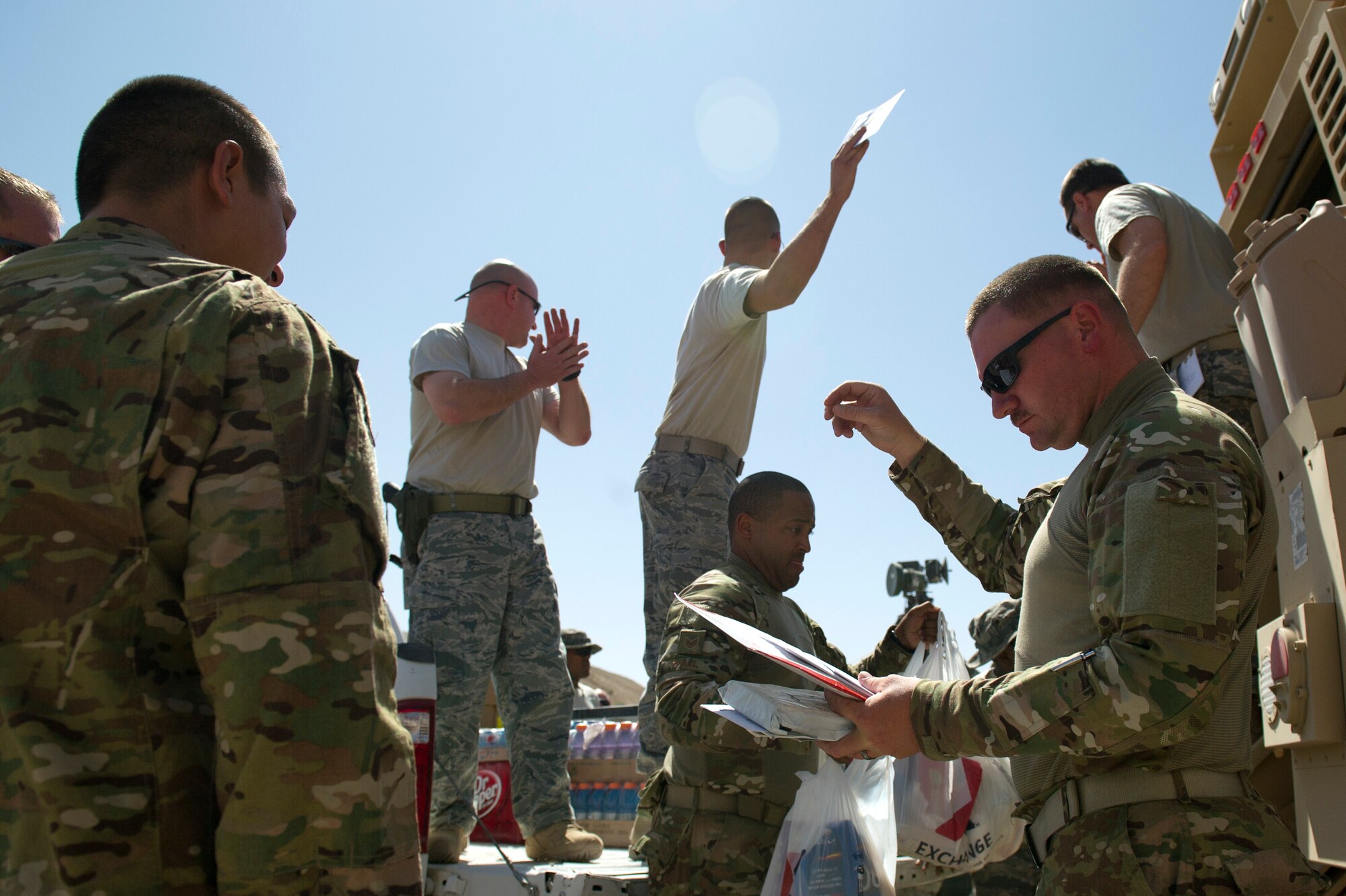 Members of Detachment 1, 73rd Expeditionary Air Control Squadron gather around as mail is passed out. Mail is only delivered to a nearby base, the 73rd EACS must periodically convoy to the base in order to get the mail to their camp. Airmen eager to get their mail usually greet the returning trucks. (U.S. Air Force Photo/Master Sgt. Jeffrey Allen)