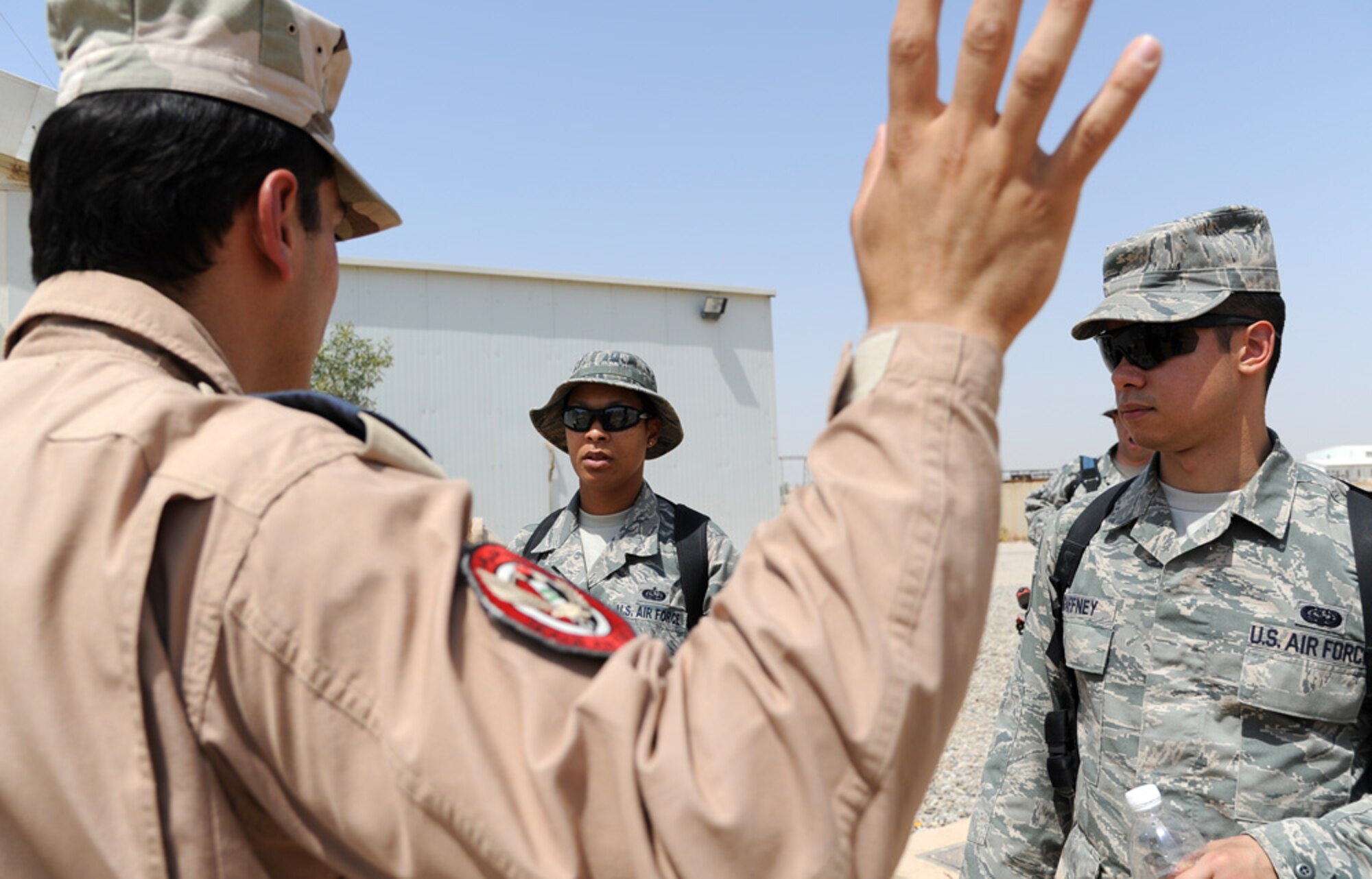 U.S. Air Force Tech. Sgt. Toya Stone and Staff Sgt. James Gaffney talks to an Iraqi Air Force officer about their communication abilities and any problems they have been having at Kirkuk Air Base, Iraq. Working along side each other, the sergeants combine their computer and radio expertise to point the Iraqis towards success.  (U.S. Air Force photo by Seniro Airman Tristin English)