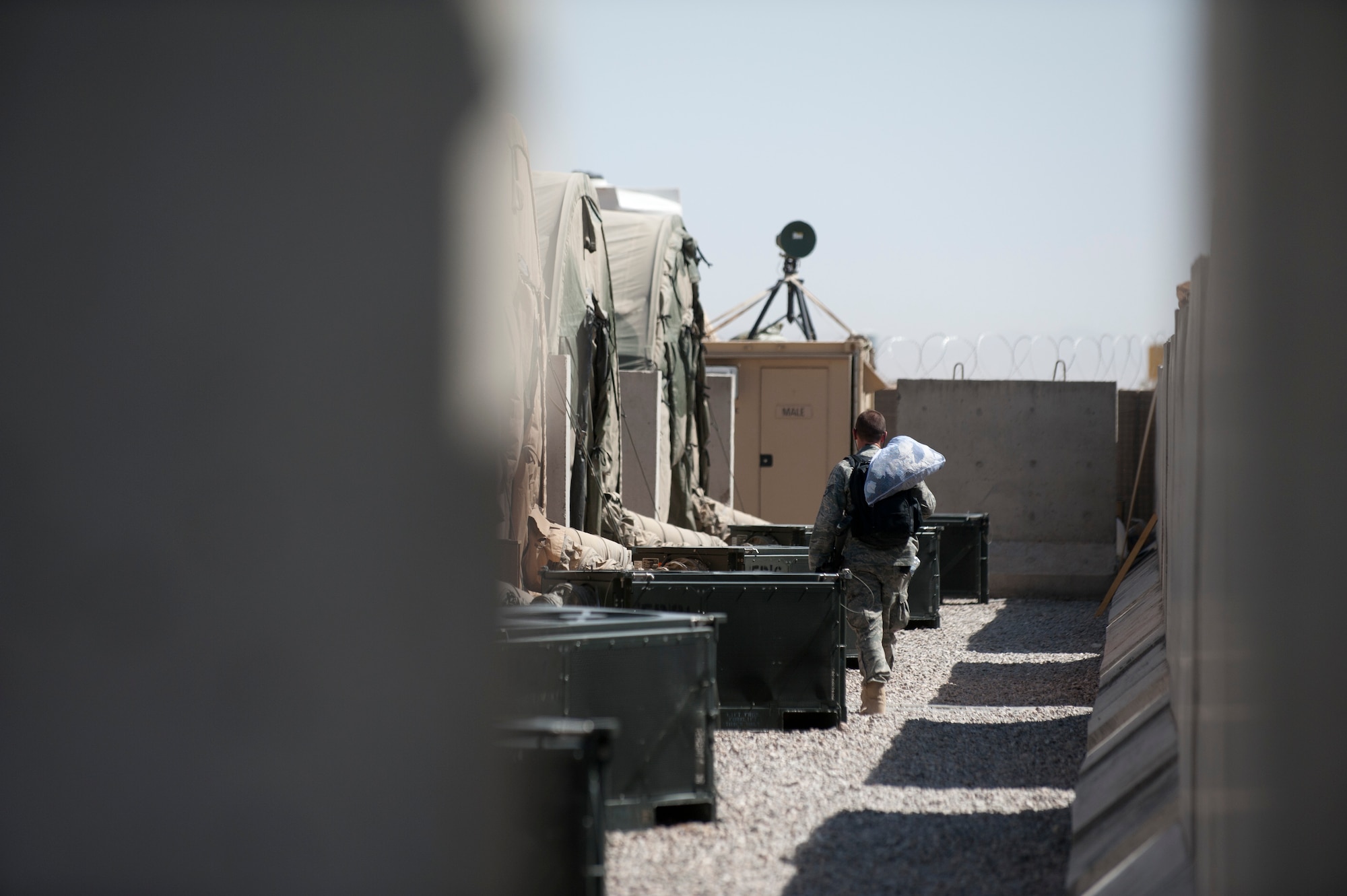 A member of Detachment 1, 73rd Expeditionary Air Control Squadron carries his laundry to his tent. (U.S. Air Force Photo/Master Sgt. Jeffrey Allen)