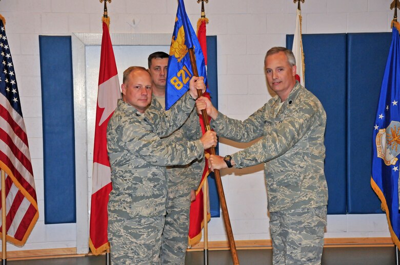 THULE AIR BASE, Greenland – Col. Chris Crawford, 21st Space Wing commander (left), presents the 821st Air Base Group guidon to Lt. Col William Uhlmeyer, 821st ABG commander, during a change of command ceremony July 21, 2011. Thule AB is one of the six installations operated by the 21st Space Wing, and is located 750 miles north of the Arctic Circle. (Courtesy photo)