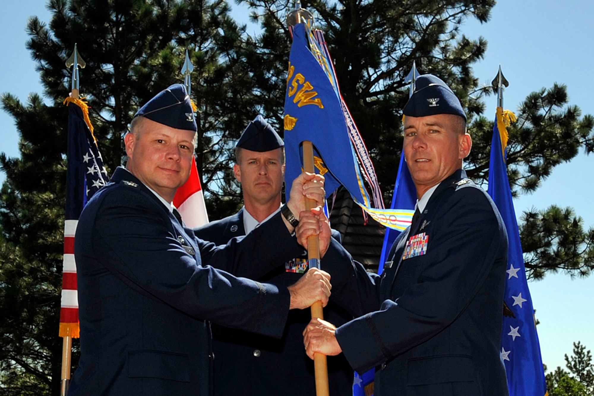 CHEYENNE MOUNTAIN AIR FORCE STATION, Colo. –Col. Chris Crawford (left), 21st Space Wing commander, passes the 721st Mission Support Group guidon to Col. Joseph J. Turk, 721st MSG commander, during a change of command ceremony July 28, 2011 at Mountain Man Park, Cheyenne Mountain Air Force Station. Turk assumed command from Col. Russell A. Wilson during the time-honored ceremony. (U.S. Air Force photo/Rob Bussard)