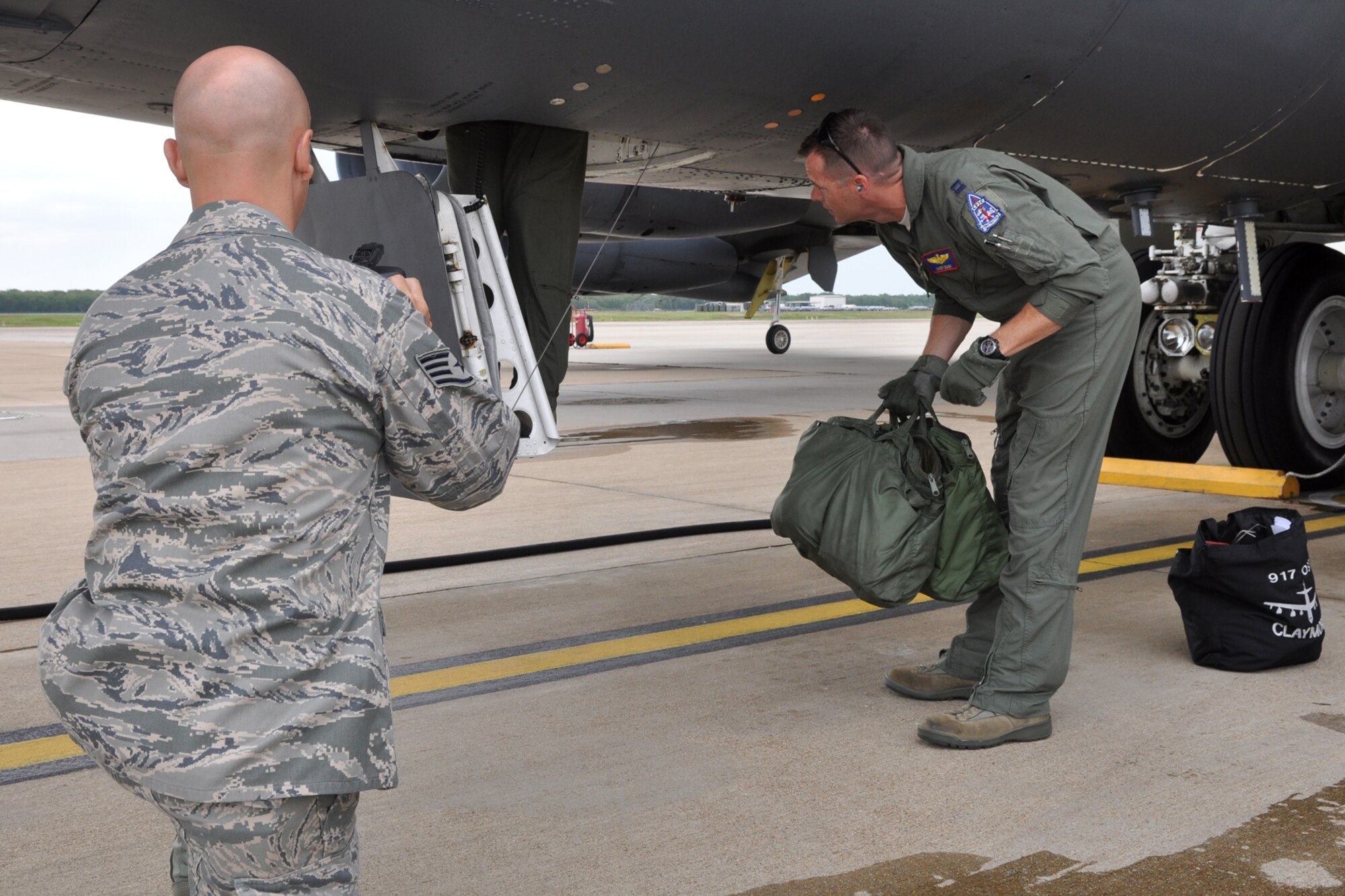 Capt. Michael Gough, a B-52 Stratofortress pilot assigned to the 93rd Bomb Squadron loads equipment in preparation for a sortie as Staff Sgt. Ted Daigle videotapes the action at Barksdale Air Force Base, La., July 25, 2011. Gough is part of the aircrew from the 93rd BS competing in the 2011 Global Strike Challenge. The competition, which is currently underway, includes bases, units and people across the country. The competition will continue through the score-posting and symposium event in November. The competition wraps up with an awards ceremony at Barksdale where trophies will be awarded to the final winners. Daigle, who is assigned to the 307th Bomb Wing Public Affairs office, was recording events to be used during the award ceremonies at the conclusion of the competition. (U.S. Air Force photo/Tech. Sgt. Jeff Walston)