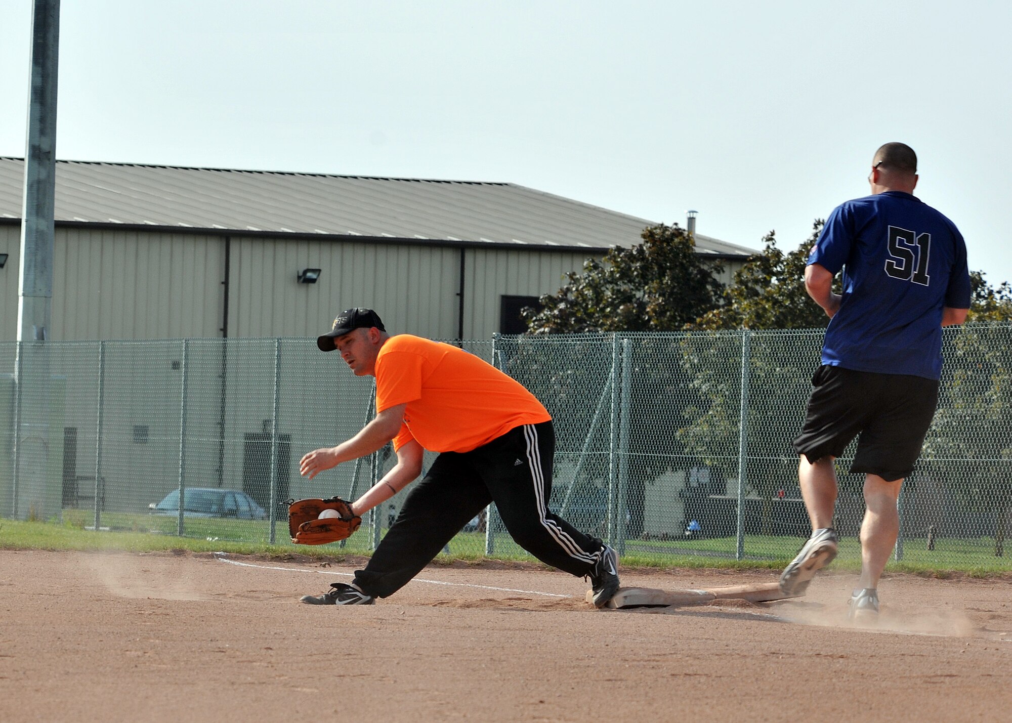 RAF MILDENHALL, England -- Richard Kelly, 100th Communications Squadron, makes an out at first base during the first game of the 100th Air Refueling Wing intramural softball playoffs here July 28, 2011. Games are Tuesdays through Thursday nights and teams are always looking for support from their units in the stands. (U.S. Air Force photo/Staff Sgt. Tabitha M. Lee)   