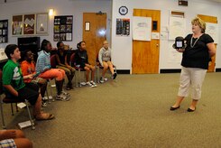 Kim Brown, a financial specialist for Joint Base Charleston - Weapons Station Fleet and Family Support Center, teaches a group of eight to 12 year-olds about federal income taxes during the FFSC Kids Financial Summer Camp at JB CHS - WS July 28. The camp was designed for children to explore the fields of entrepreneurship, finance, savings and being wise consumers. (U.S. Navy photo/ Mass Communication Specialist 3rd Class Brannon Deugan