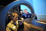 Dana Gunter (right), 559th Flying Training Squadron T-6 simulator instructor, teaches Air Force Academy Cadets (right to left)  Johnathan Fonbuena, Conner McKinney and Arturas Kucharevas how to fly the T-6 simulator on Randolph Air Force Base July 15. (U.S. Air Force photo/Rich McFadden) (released)