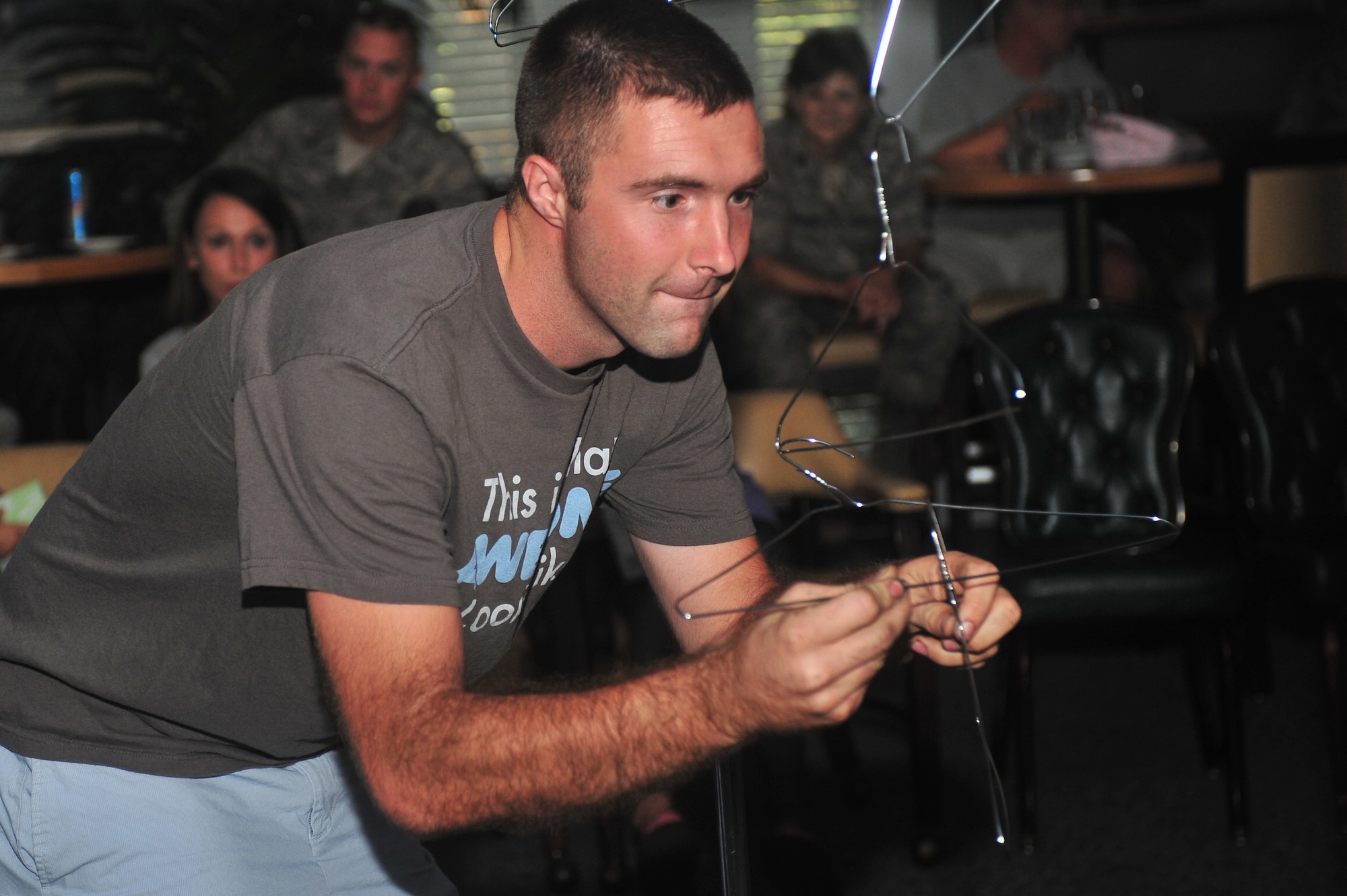 A U.S. Air Force Airman participating in a “Minute to Win It” competition tries his hand in a hanger game one of the many challenges during the event, Shaw Air Force Base, S. C. July 20, 2011. The “Minute to Win It” competition brought Airman together and showcased squadron’s teamwork. (U.S. Air Force photo by Airman 1st Class Ashley Gardner/ Released)