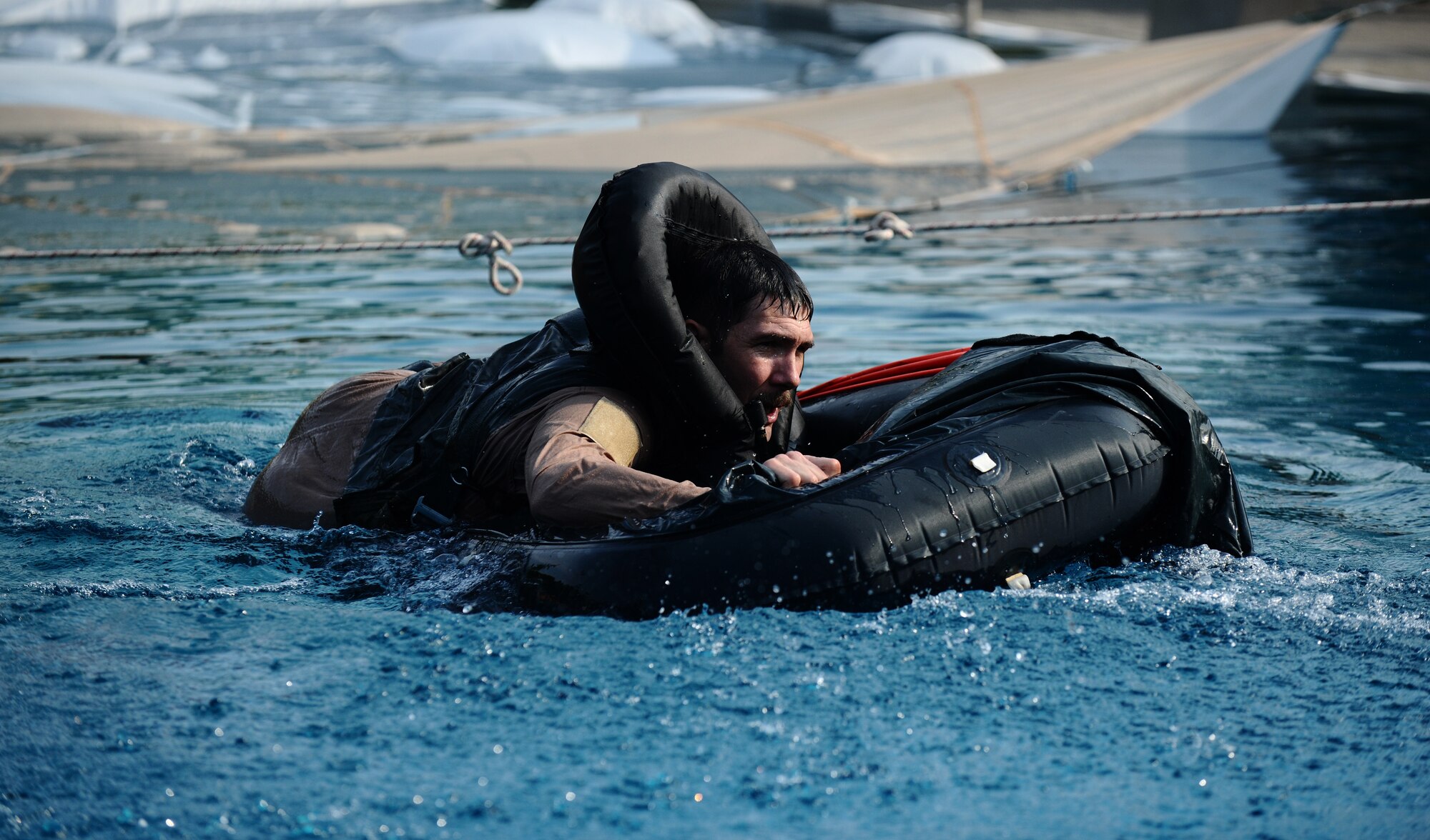 SPANGDAHLEM AIR BASE, Germany -- Tech. Sgt. Robert Martin, 52nd Fighter Wing Survival, Evasion, Resistance and Escape Training and Operations Survival NCO in charge, climbs into a life raft during water survival training here July 29. Martin demonstrated proper procedures to pilots from the 81st Fighter Squadron who must complete water survival training as part of a triennial requirement. (U.S. Air Force photo/Staff Sgt. Nathanael Callon)