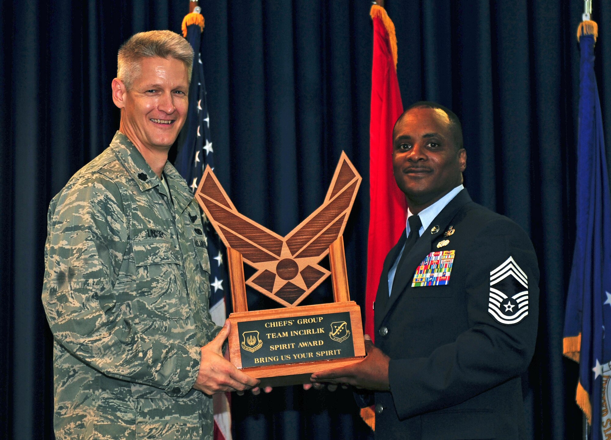 Lt. Col. Brian Lindsey, 728th Air Mobility Squadron commander, left, accepts the Chiefs’ Group Team Incirlik Spirit Award on behalf of the squadron during the monthly promotion ceremony July 29, 2011, at the Club Complex ballroom at Incirlik Air Base, Turkey. (U.S. Air Force photo by Senior Airman Anthony Sanchelli/Released)
