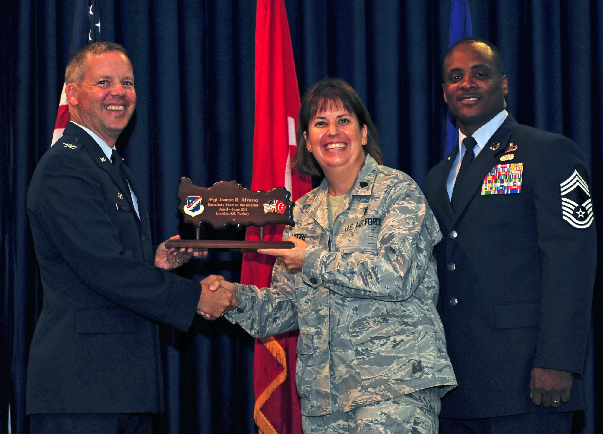 Lt. Col. Lisa Moore, 39th Medical Support Squadron commander, accepts the Dormitory Room of the Quarter Award on behalf of Staff Sgt. Joseph Alvarez, 39th Medical Operations Squadron July 29, 2011, at the Club Complex ballroom at Incirlik Air Base, Turkey. (U.S. Air Force photo by Senior Airman Anthony Sanchelli/Released)
