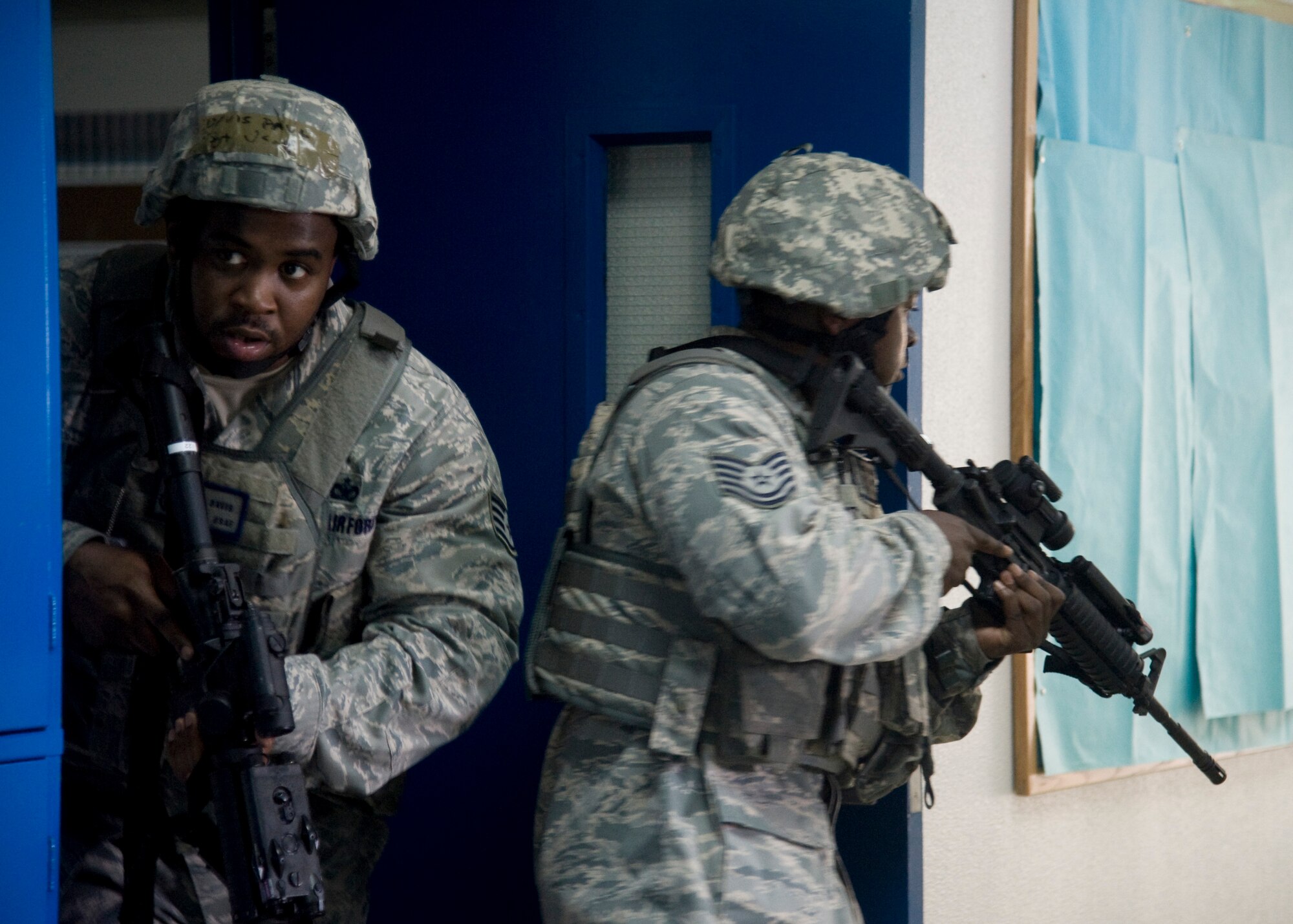 YOKOTA AIR BASE, Japan -- Staff Sgt. Paul Davis (left) and Tech. Sgt. Harold Thomas, 374th Security Forces Squadron members, survey the surrounding area for dangers outside a classroom during the High Risk Response Training course at Yokota Air Base, Japan, July 27, 2011. The course emphasizes situational awareness to help keep security forces members safe during a potentially high-risk response. (U.S. Air Force photo/Senior Airman Andrea Salazar)