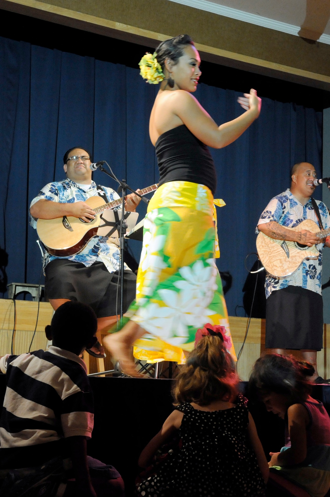 MISAWA AIR BASE, Japan -- Children sit on the dance floor and watch as Ma'ohi Nui performs traditional Polynesian music and dances during a luau at the Misawa Collocated Club July 29. Ma'ohi Nui performed at Misawa Air Base as part of an Armed Forces Entertainment tour in support of military members and their families. (U.S. Air Force photo/Staff Sgt. Marie Brown/Released)