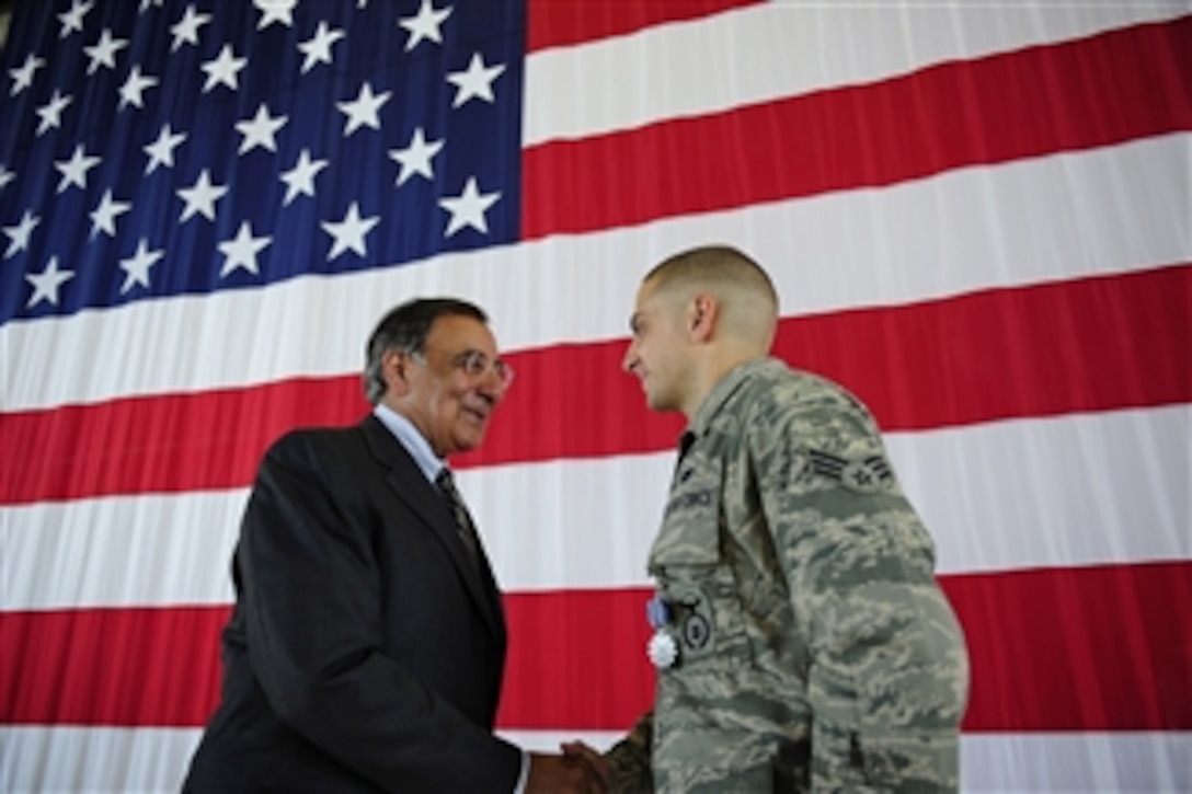 Secretary of Defense Leon E. Panetta shakes hands with Senior Airman Brian Colasacco after presenting him an Air Force Achievement Medal during a ceremony at Peterson Air Force Base, Colo., on July 29, 2011.  Colassaco received the medal for aiding an Afghani citizen suffering from an open abdominal wound.  He took immediate action and employed life-saving care until the arrival of paramedics.  