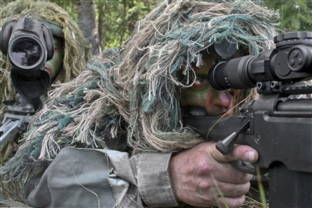 Air Force Staff Sgt. George Reinas and Senior Master Sgt. Nathan Brett practice a scenario on a range on Joint Base Lewis-McChord, Wash., July 27, 2011. Reinas and Brett are snipers, and were the event coordinators for the advanced marksmanship event for Air Mobility Rodeo 2011. Brett is the superintendent of the U.S. Air Force Expeditionary Center's 421st Combat Training Squadron at Joint Base McGuire-Dix-Lakehurst, N.J., and Reinas is its security forces combat skill instructor.