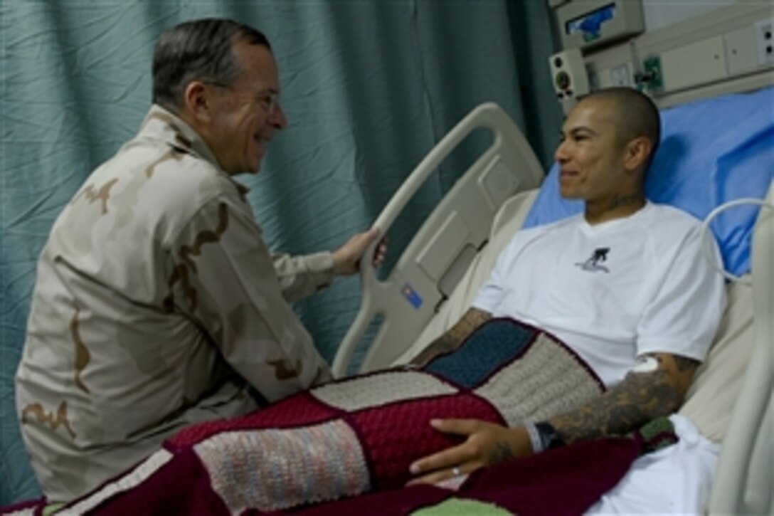 U.S. Navy Adm. Mike Mullen, chairman of the Joint Chiefs of Staff, visits with U.S. Army Spc. Rosasgarza Francisco, a patient at Craig Joint Theater Hospital at Bagram Airfield, Afghanistan, Aug. 1, 2011. 