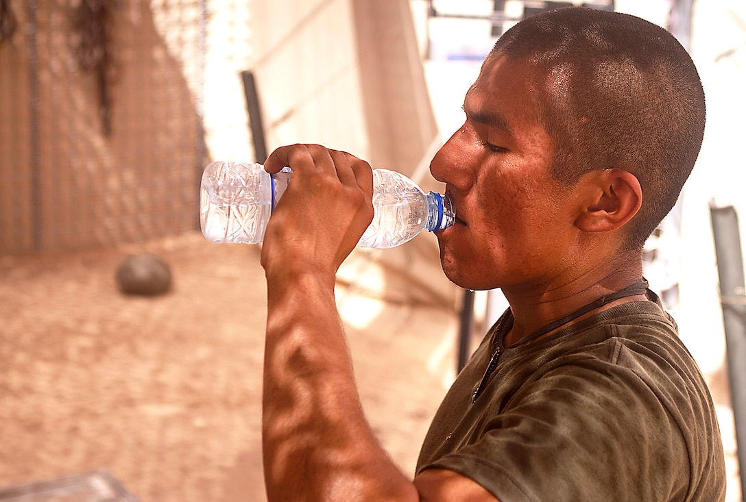 Lance Cpl. Jose Contreras quenches his thirst while completing the Rankel Workout here, Aug. 1. Contreras, a native of San Antonio, is a team leader with Charlie Company, 1st Battalion, 3rd Marine Regiment. The Rankel workout is dedicated to Sgt. John Rankel, who died while deployed here in 2010.