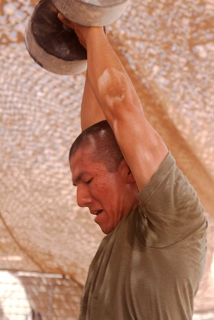Lance Cpl. Jose Contreras completes a kettle bell swing as part of the Rankel Workout here, Aug. 1. Contreras, a native of San Antonio, is a team leader with Charlie Company, 1st Battalion, 3rd Marine Regiment. The Rankel workout is dedicated to Sgt. John Rankel, who died while deployed here in 2010.