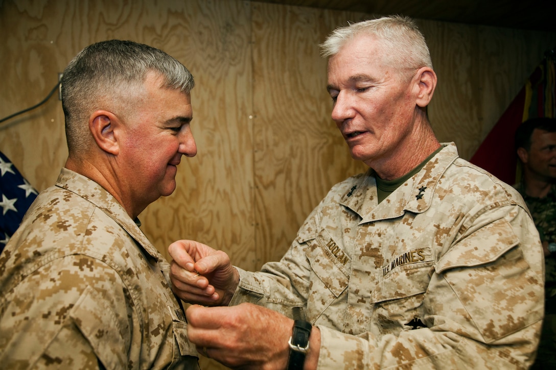 Maj. Gen. John A. Toolan, right, the commanding general of Regional Command Southwest, prepares to promote Maj. Gen. Glenn M. Walters, left, the commanding general of 2nd Marine Aircraft Wing (Forward), to his current rank at Camp Leatherneck, Afghanistan, August 2. In Afghanistan, Walters leads the aviation combat element in support of NATO International Security Assistance Force’s Regional Command Southwest.