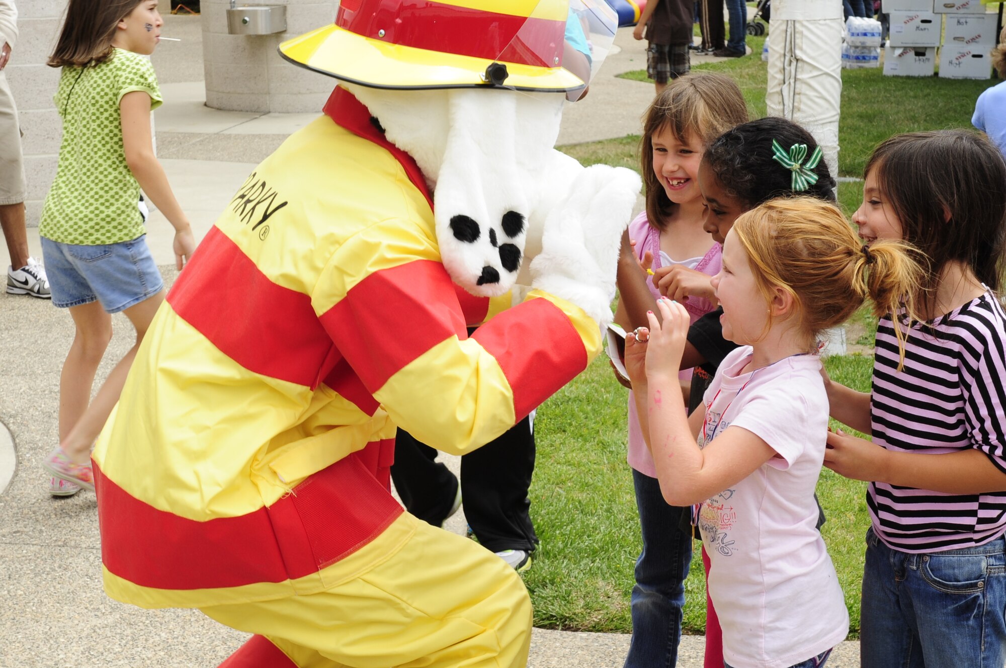 VANDENBERG AIR FORCE BASE, Calif. – Sparky, the Vandenberg Fire Department’s mascot, greets four girls with high-fives during the Salute to Youth event at the Youth Center here Friday, July 29, 2011. The Base fire department showed children at the event the different fire engines and also simulated an escape from a smoke filled building. (U.S. Air Force photo/Senior Airman Lael Huss)