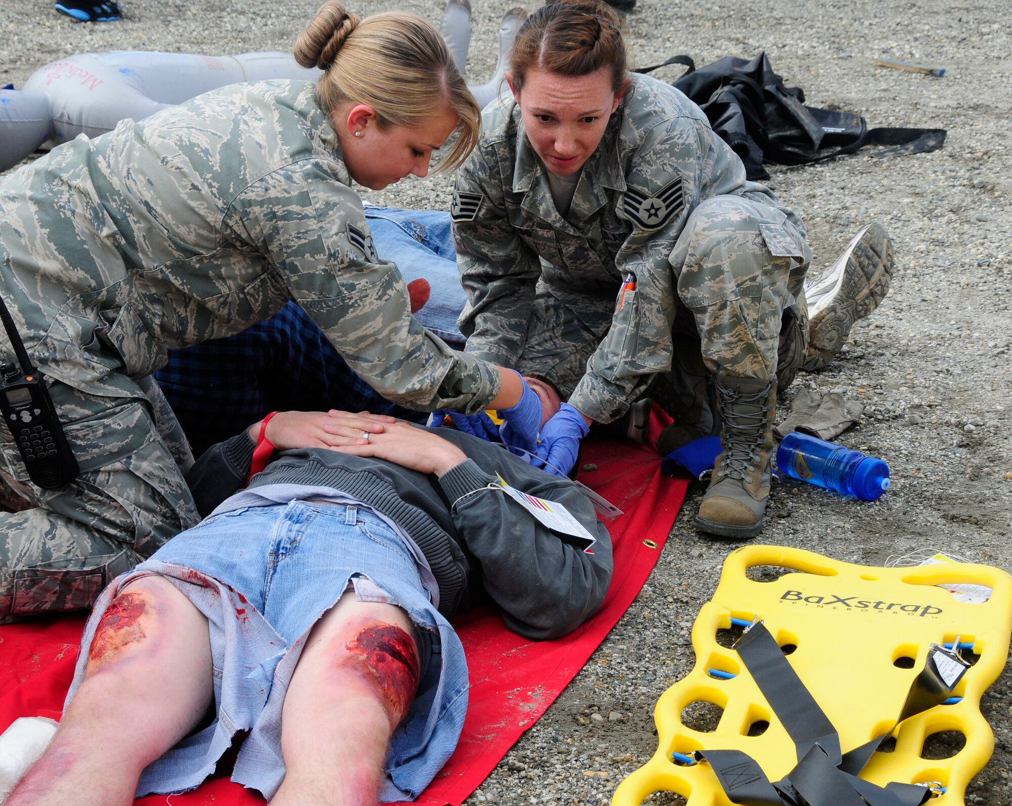 Airman 1st Class Michelle Sabo and Staff Sgt. Kristy Raso stabilize a victim during an emergency management exercise at the University of Alaska, Fairbanks campus July 27, 2011. The exercise tested the abilities of civilian and military emergency services during a simulated crisis at the university. Airman Sabo and Sergeant Raso are both emergency medical technicians assigned to the 354th Medical Operations Squadron. (U.S. Air Force photo/Senior Airman Rachelle Coleman)