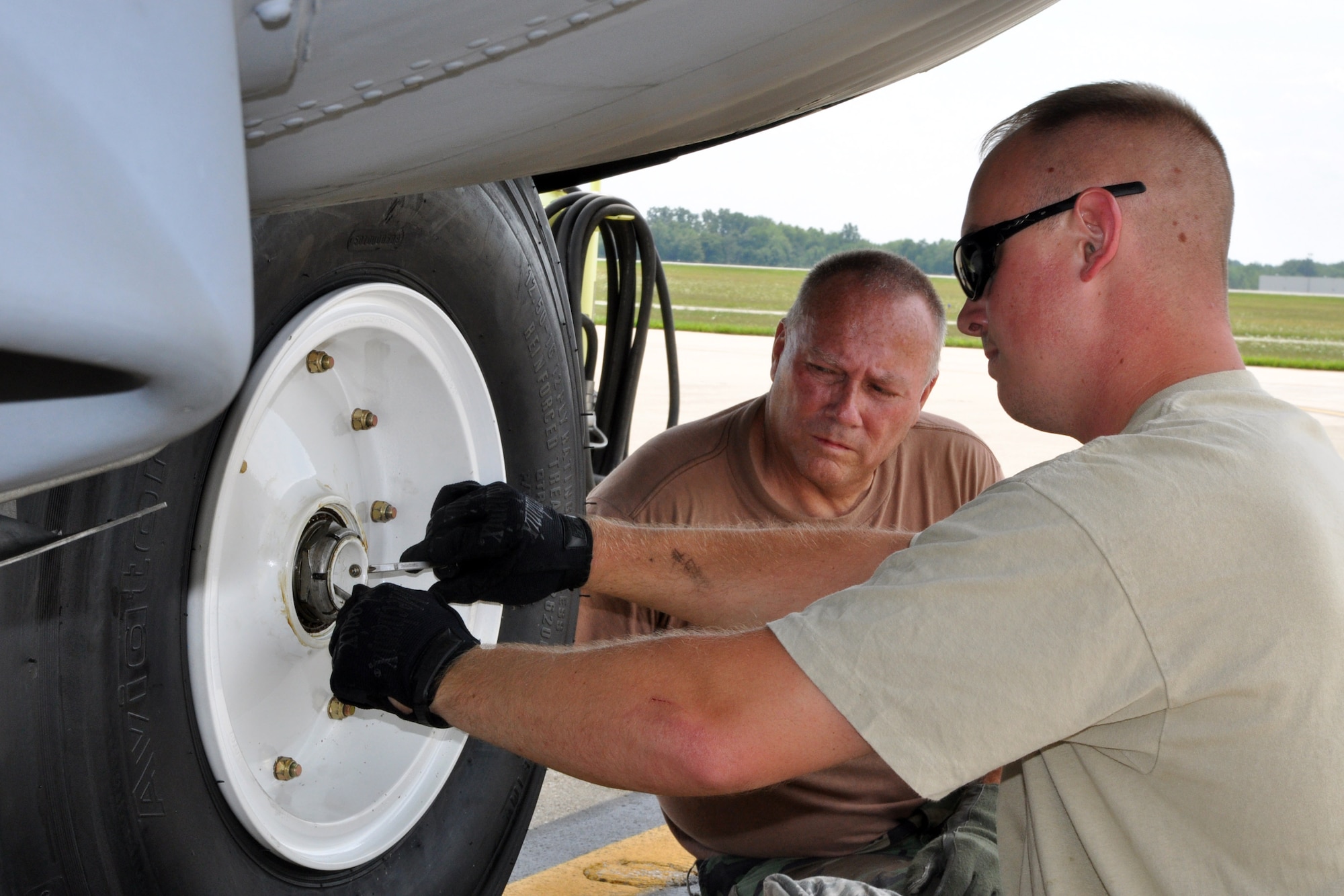 YOUNGSTOWN AIR RESERVE STATION, Ohio -- Air Force Reserve Staff Sgt. Evan Hart, a assistant crew chief with the 910th Aircraft Maintenance Squadron, puts the finishing touches on replacing a nose landing gear tire on his assigned C-130H Hercules cargo transport aircraft as the aircraft's primary crew chief, Master Sgt. Ernie Johnson, also with the 910th AMXS, checks his work on the flightline here, August 2, 2011. Sergeants Hart and Johnson are performing the work as part of the continuously scheduled maintenance that keeps the 12 C-130s assigned to the 910th Airlift Wing in good flying order and ready to complete the wing's airlift, airdrop and aerial spray missions anytime, anywhere around the globe at a moment's notice. U.S. Air Force photo by Master Sgt. Bob Barko Jr.