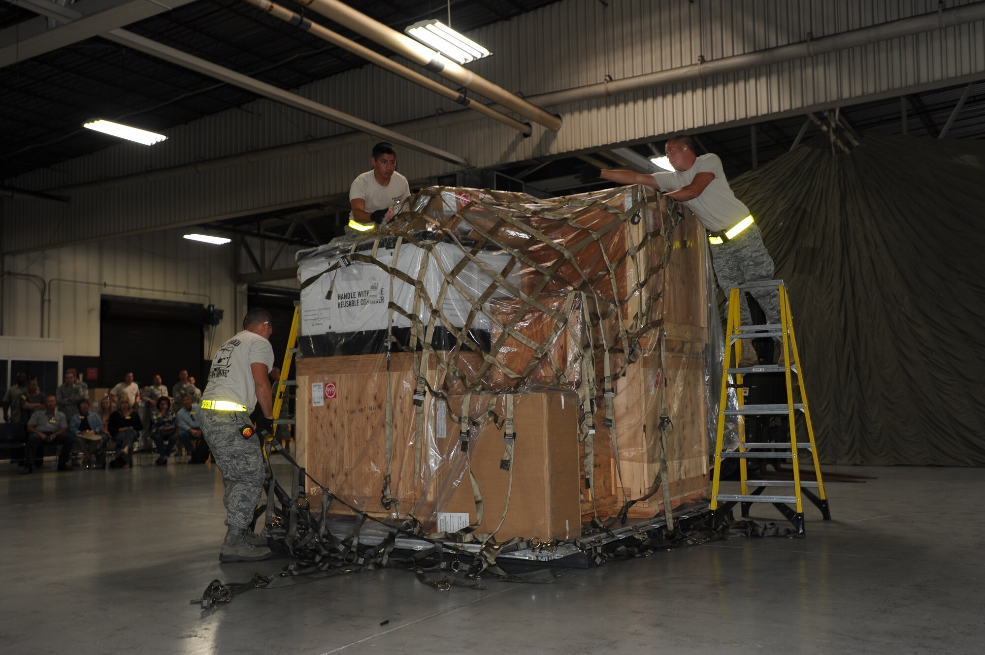 Staff Sgt. Jesus Trejo (left), a special handling supervisor with the 436th Aerial Port Squadron, Airman 1st Class David Tovar and Senior Airman Benjamin Johnson, both passenger services representatives with the 436 APS, secure a pallet during a timed pallet build-up competition at 2011 Air Mobility Command's Rodeo competition at Joint Base Lewis-McChord, Wash. (U.S. Air Force photo by 2nd Lt. Jennifer Guerrero)