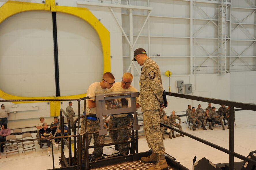 Staff Sgt. Eric Yuckel (left) with the 712th Aircraft Maintenance Squadron, and Staff Sgt. Chance Wisdom with the Aircraft Maintenance Squadron, remove and reinstall a simulated hydraulic component from a C-17 Globemaster III at Joint Base Lewis-McChord, Wash. Master Sgt. Michael Murray, an umpire for the 2011 Air Mobility Command Rodeo, is overlooking this scenario. (U.S. Air Force photo by 2nd Lt. Jennifer Guerrero)