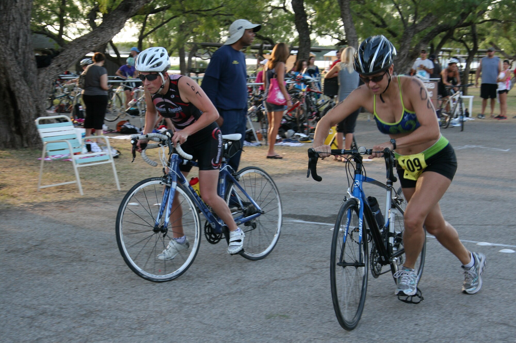 GOODFELLOW AIR FORCE BASE, Texas – Adrianne Brakefiel (left) and Marisa Lengerich, 315th Training Squadron student, mount their bikes for a 20-kilometer ride, after completing the 400-meter open water swim at the Outdoor Recreation Camp July 30. Lengerich won first place overall in the female category. (Courtesy photo/Julie Manuel)