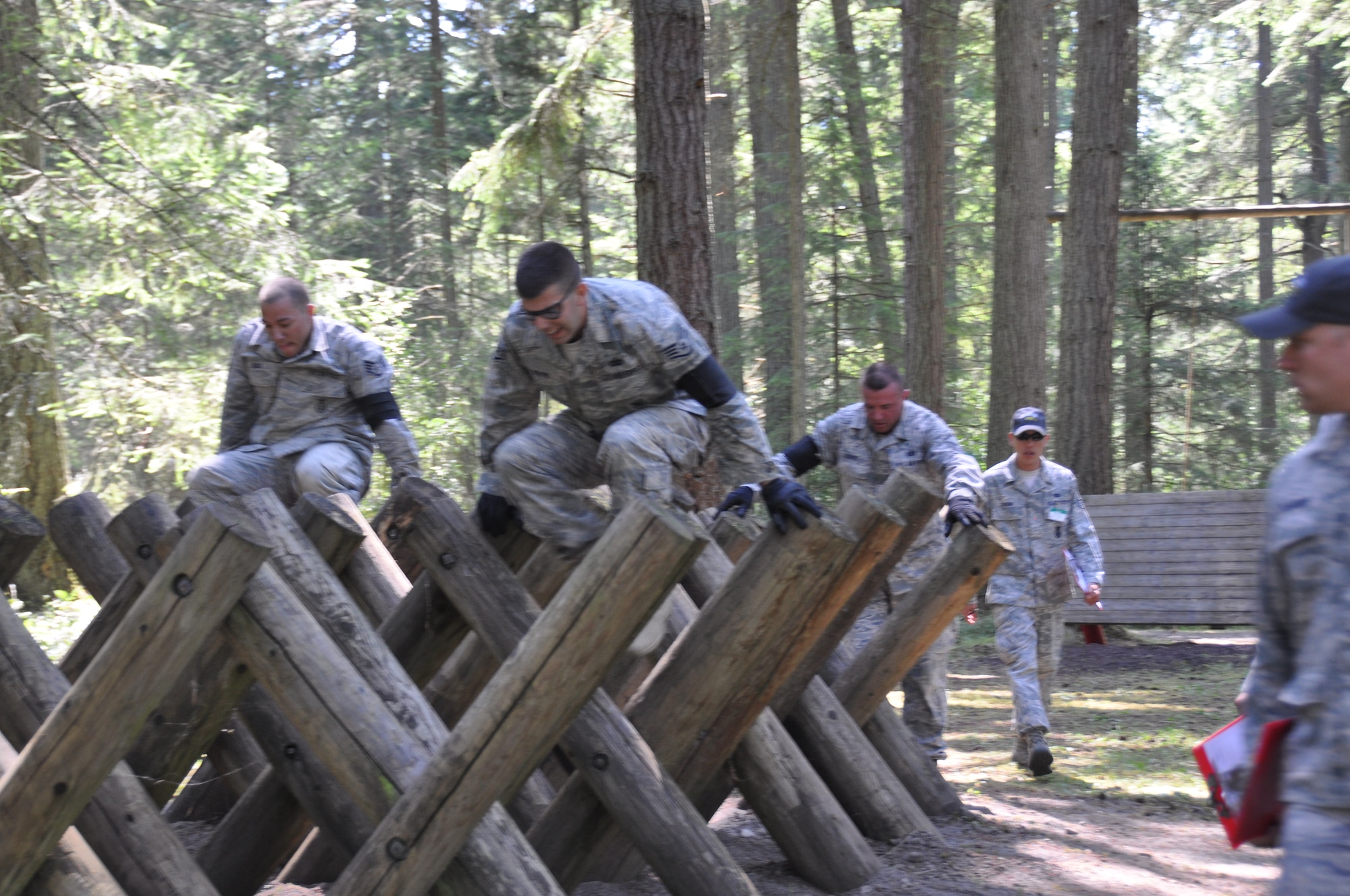 Staff Sgt. Nicholas Russo (left), a Combat Arms instructor with the 436th Security Forces Squadron, Staff Sgt. Mark Devine, a raven with the 436 SFS, and Master Sgt. Sean Burke, NCO in charge of 436 SFS Support Operations, perform a high step over during the Combat Endurance Course (DATE) at Joint Base Lewis-McChord, Wash. This course, along with combat tactics course, contributed to the Best Airland Team Award received by Team Dover at the 2011 Air Mobility Command Rodeo competition. (U.S. Air Force photo by Airman 1st Class Michael Battles)