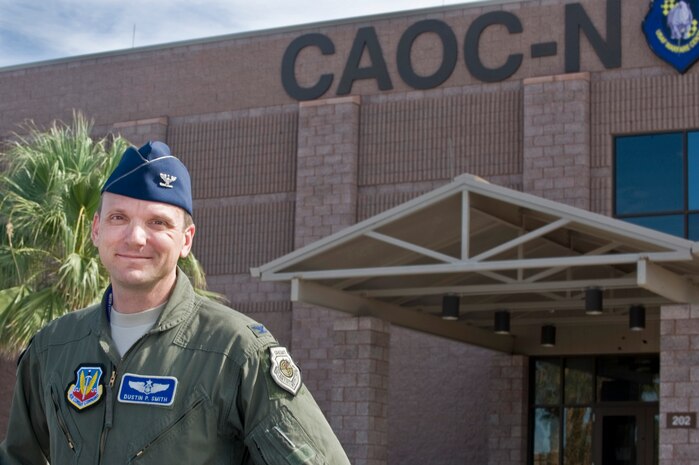 U.S. Air Force Col. Dustin P. Smith,  505th Test and Evaluation Group commander, stands in front of the Combined Air Operations Center July 28, 2011, at Nellis Air Force Base, Nev. Smith is responsible for developing operational- to tactical-level tactics, techniques and procedures supporting air, space and cyber integration; conducting advanced training for air and space operations center personnel; and conducting operational tests for elements of the theater air control system and selected intelligence, surveillance and reconnaissance weapons systems.  The 505th TEG includes four active duty squadrons, two detachments and 11 operating locations.  (U.S. Air Force photo by Airman 1st Class Matthew Lancaster/Released)