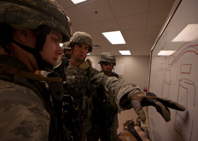 U.S. Air Force Senior Airman Jared Boucher, 96th Security Forces Squadron squad leader from Eglin, Air Force Base, Fla., goes over the way of entry into the military operations in urban terrain village training facility during the squad leadership course at Moody Air Force Base, Ga., July 29, 2011. The scenario for the training mission was to enter the village to speak with the village leader to exchange information about possible terrorist activity. (U.S. Air Force photo by Airman 1st Class Joshua Green/Released)
