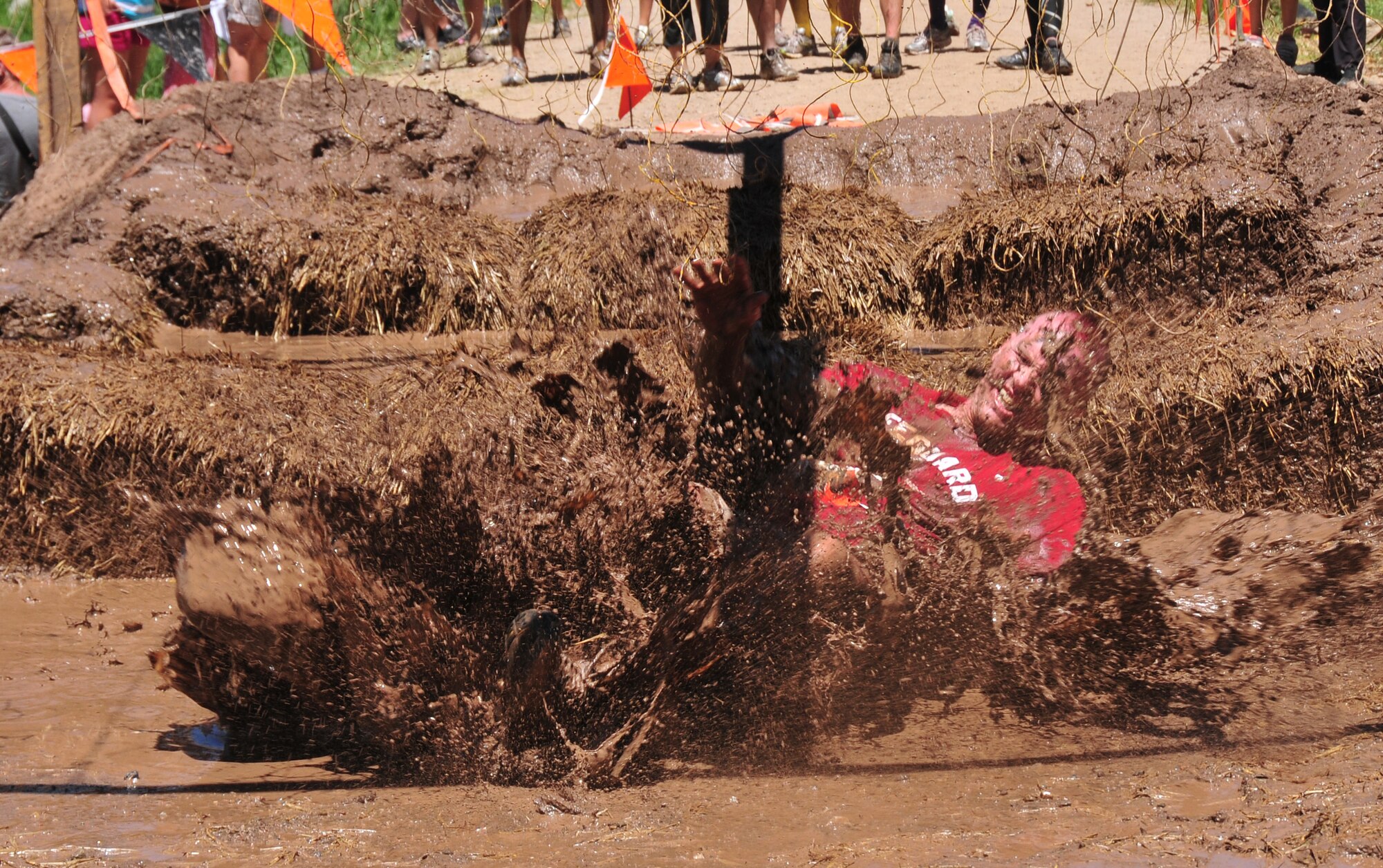 310th Space Wing member Staff  Sgt. Conrad Jones falls following a 10,000 shock in the Electroshock Therapy obstacle at the Tough Mudder in Avon, Colo. on June 26. The Electroshock Therapy was one of 25 obstacles in the 9-mile challenge that took challengers through 4,000 feet in elevation changes. (U.S. Air Force photo/Tech. Sgt. Nick Ontiveros)