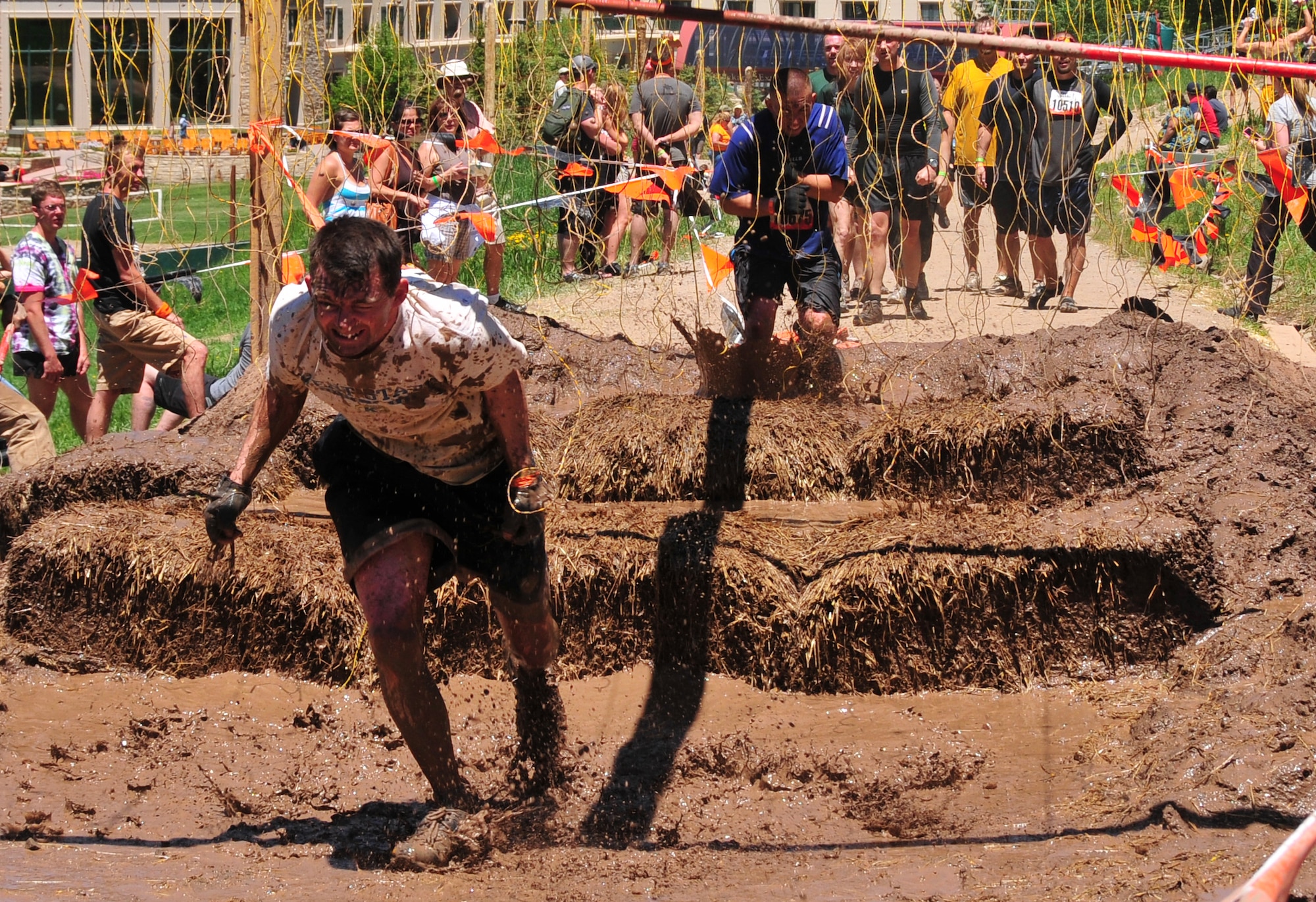 310th Space Wing member Master Sgt. Eric Vesey makes his way through the Electroshock Therapy obstacle at the Tough Mudder in Avon, Colo. on June 26. The Electroshock Therapy was the final obstacle of the challenge in which participants run through lives wires, some of which carry a 10,000 volt shock. (U.S. Air Force photo/Tech. Sgt. Nick Ontiveros)
