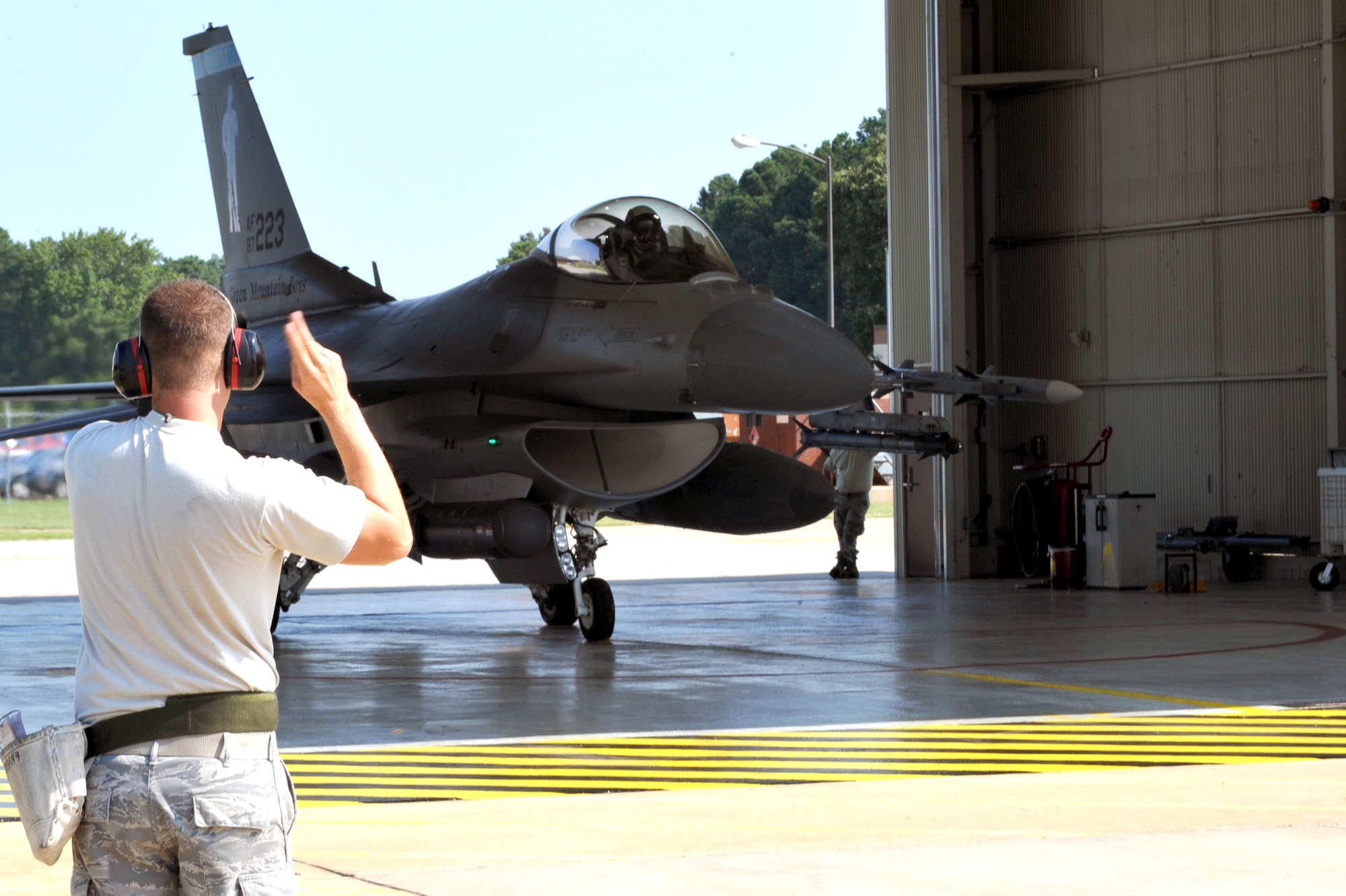 Senior Airman Jeremy Devlin, 158th Fighter Wing crew chief directs Maj. Nathan Graber, 158th Fighter Wing pilot, as he taxis his F-16 Fighting Falcon to a runway at Langley Air Force Base, Va. Aug. 1, 2011. The Airmen are part of an Air National Guard from Vermont known as the “Green Mountain Boys” and remain on alert 365 days a year to provide immediate airpower to the nation’s defense.  (U.S. Air Force photo by Staff Sgt. Logan Tuttle/Released)