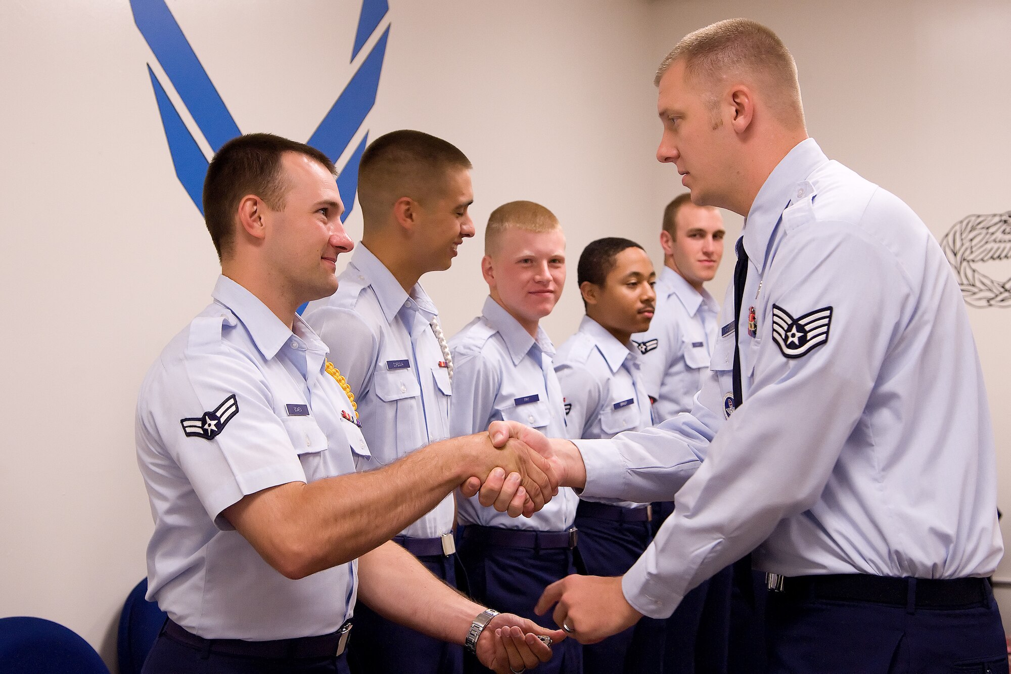 Airman 1st Class Matthew Bowen, C-5 Galaxy crew chief, accepts his occupational badge from Staff Sgt. Benjamin Mattingly, 373rd Training Squadron instructor, during Bowen’s graduation ceremony July 29, 2011, at Dover Air Force Base, Del. Bowen was one of seven Airmen who became the Air Force’s newest C-5 crew chiefs. (U.S. Air Force photo by Adrian Rowan) 