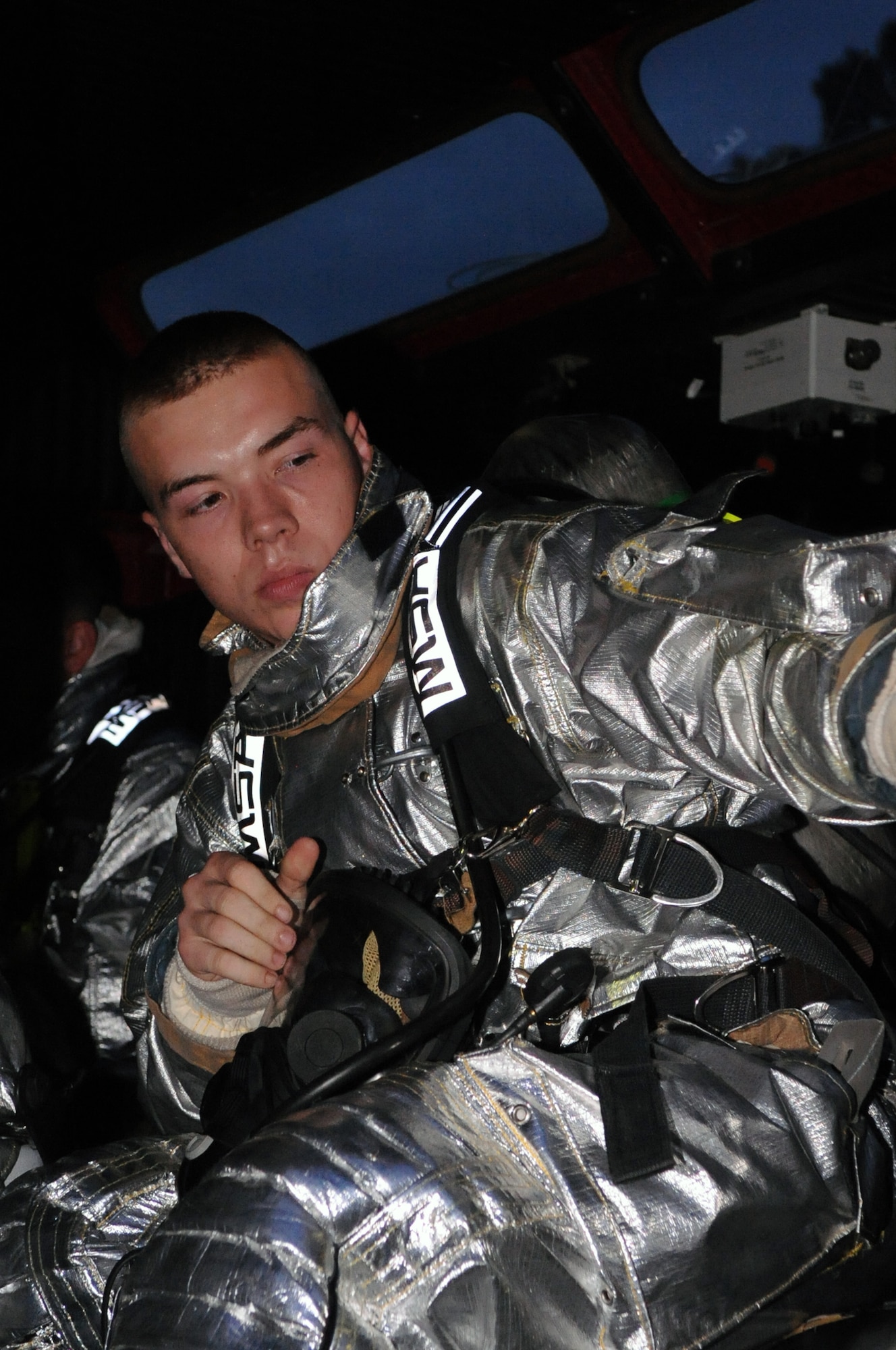 Airman 1st Class Logan Hoffman, 2nd Civil Engineer Squadron, prepares to close the door of a fire truck after suiting up to respond to a call on Barksdale Air Force Base, La., July 28. The 2 CES responded to a simulated fire in the old east side housing area, which is scheduled for demolition. Four houses were used to simulate two fires, a building collapse and a gas leak. The scenario was part of a joint training exercise between Barksdale firefighters and the Bossier City firefighters. (U.S. Air Force photo/Senior Airman La'Shanette V. Garrett) (RELEASED)