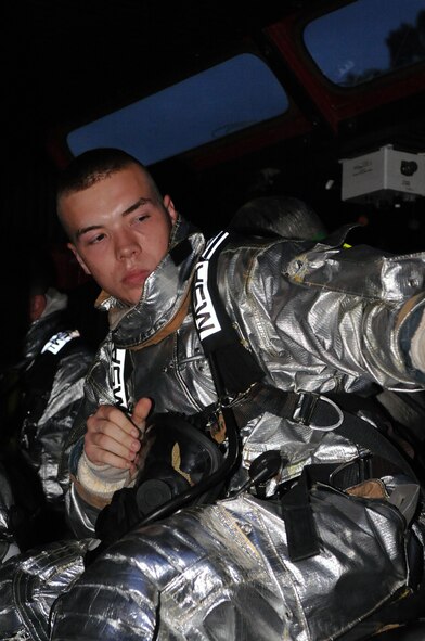 Airman 1st Class Logan Hoffman, 2nd Civil Engineer Squadron, prepares to close the door of a fire truck after suiting up to respond to a call on Barksdale Air Force Base, La., July 28. The 2 CES responded to a simulated fire in the old east side housing area, which is scheduled for demolition. Four houses were used to simulate two fires, a building collapse and a gas leak. The scenario was part of a joint training exercise between Barksdale firefighters and the Bossier City firefighters. (U.S. Air Force photo/Senior Airman La'Shanette V. Garrett) (RELEASED)
