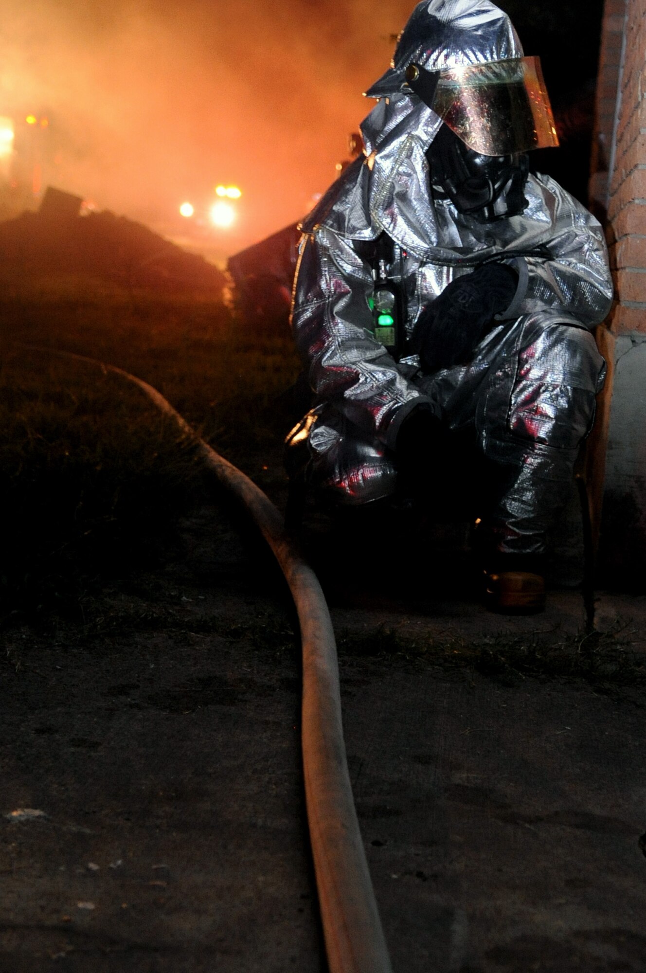 A firefighter with the 2nd Civil Engineer Squadron responds to a simulated fire in the old east side housing area on Barksdale Air Force Base, La., July 28, which is scheduled for demolition. The scenario was part of a joint training exercise between Barksdale firefighters and the Bossier City firefighters. (U.S. Air Force photo/Senior Airman La'Shanette V. Garrett) (RELEASED)