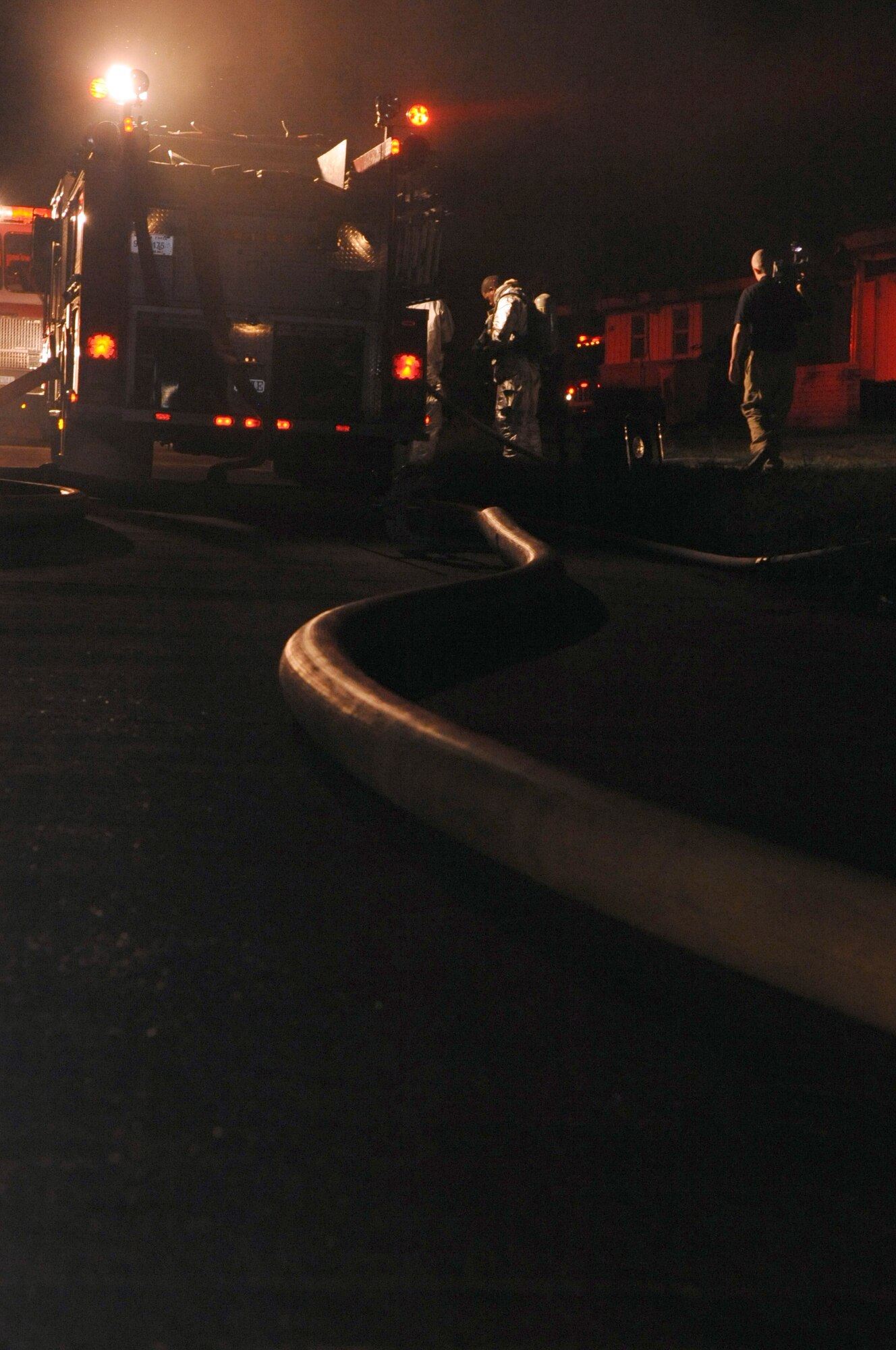 Firefighters with the 2nd Civil Engineer Squadron respond to a simulated fire in the old east side housing area on Barksdale Air Force Base, La., July 28, which is scheduled for demolition. Four houses were used to simulate two fires, a building collapse and a gas leak. (U.S. Air Force photo/Senior Airman La'Shanette V. Garrett) (RELEASED)