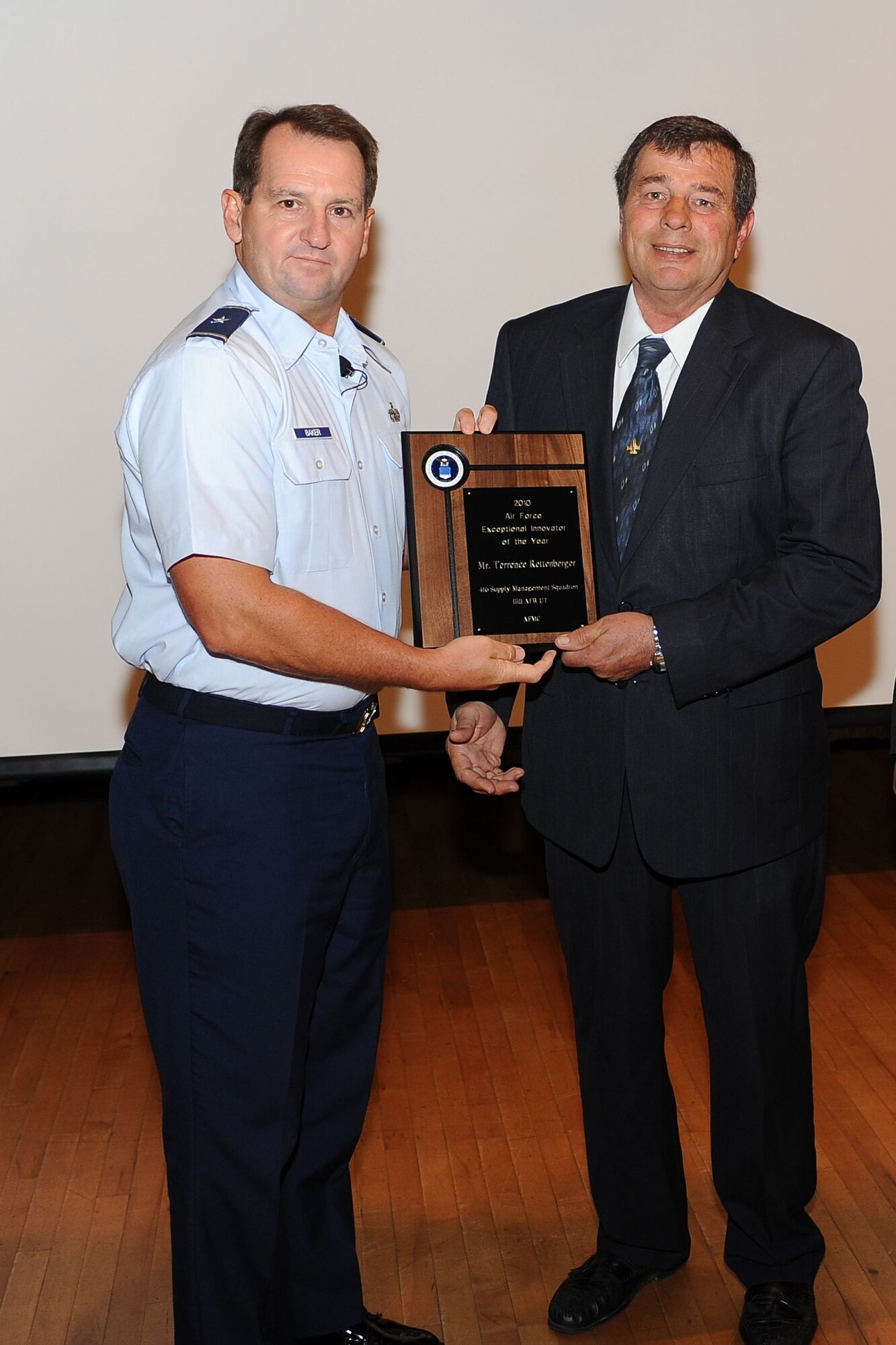 Terry Rettenberger, equiqment specialist for the 416th Supply Managment Squadron,  is presented the Exceptional Innovator of the year award from Brig. Gen. Brent H. Baker Sr., Air Force Global Logistics Support Center Commander from Scott Air Force Base, IL. (U.S Air Force photo by Vic Rivera)
