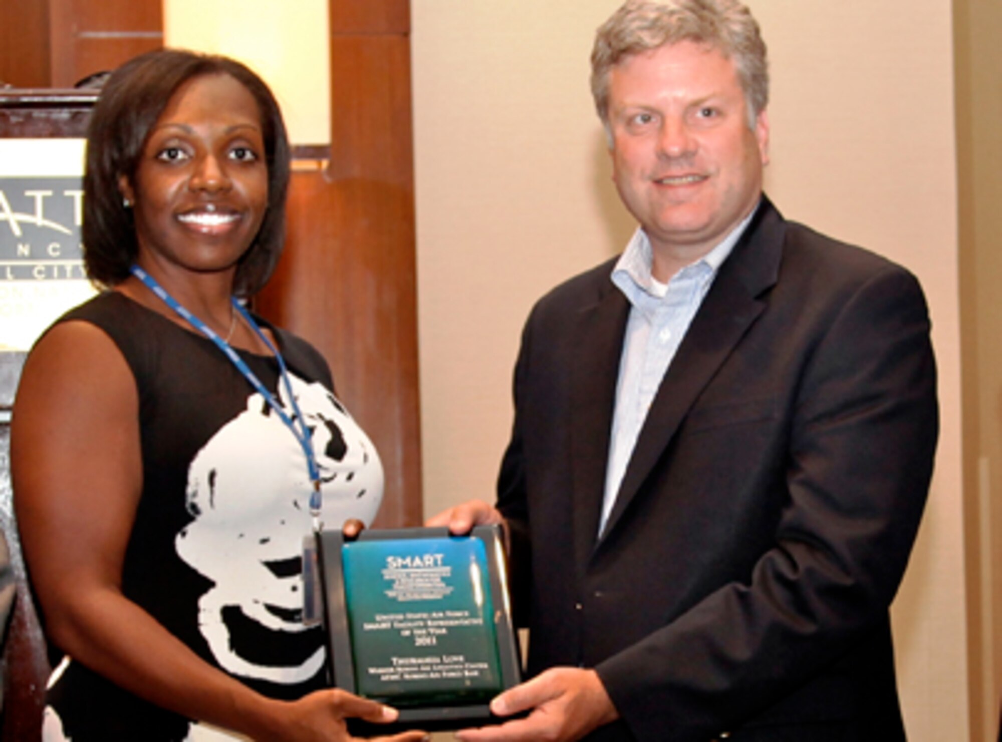 Dr. Steven Walker (right), deputy assistant secretary of the Air Force for science, technology and engineering, presents the 2011 Outstanding Air Force SMART Point of Contact award to Maci O. Love, scientist and engineering recruiting, Warner-Robins Air Logistics Center, Robins AFB, Ga. (Courtesy photo/Matthew Rose, SMART Program)