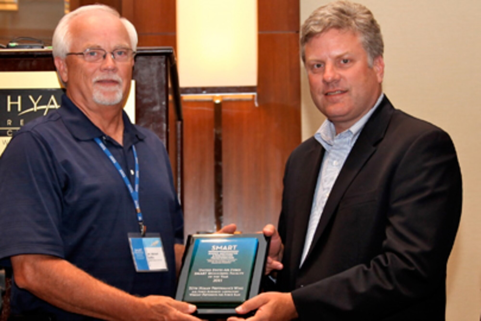 Dr. Steven Walker (right), deputy assistant secretary of the Air Force for science, technology and engineering, presents the 2011 Outstanding Air Force SMART Organization award to the 711th Human Performance Wing, Air Force Research Lab, Wright-Patterson AFB, Ohio, represented by Mike Griffin, wing office of the chief scientist. (Courtesy photo/Matthew Rose, SMART Program)