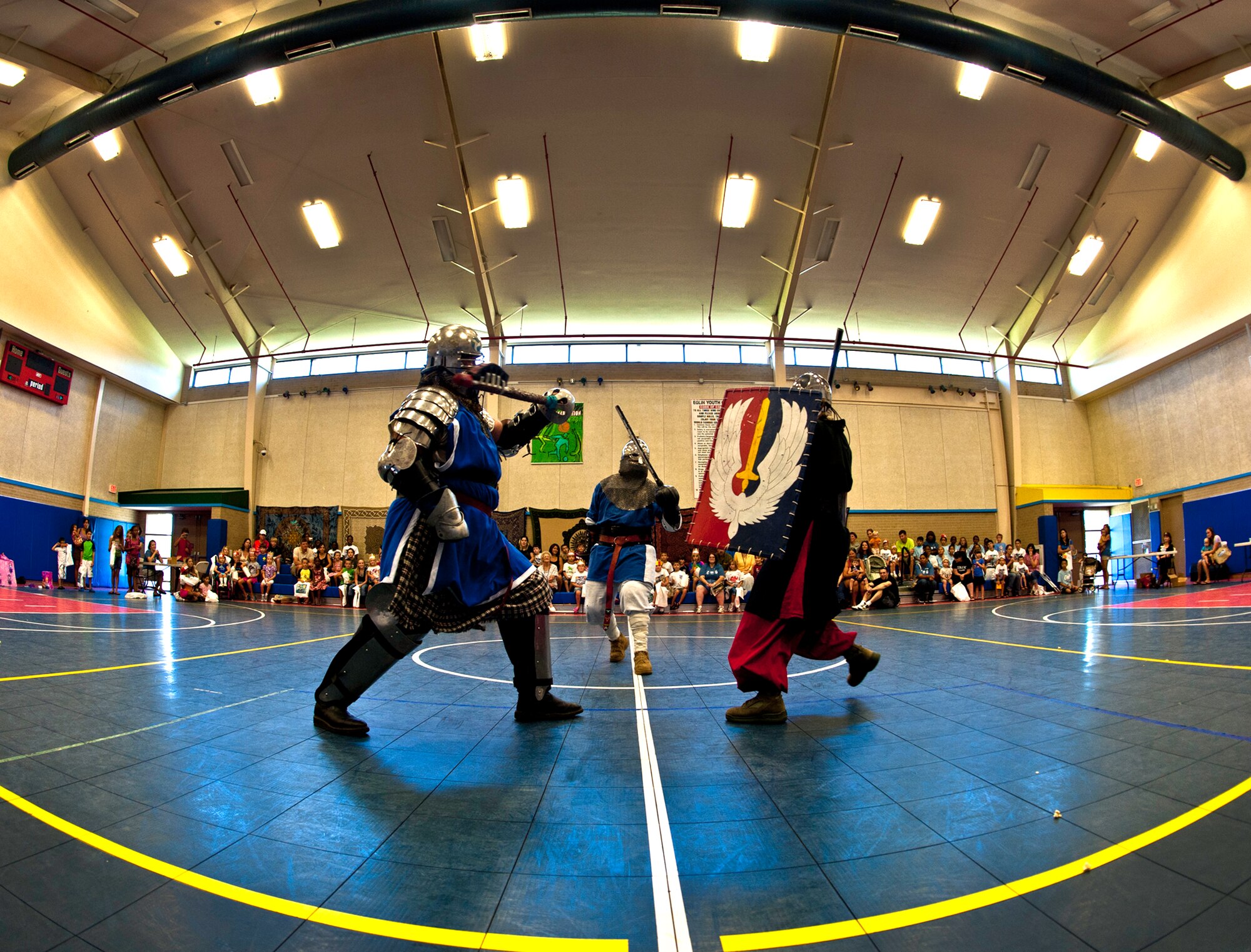 Armored knights Cody Beard, Mike Heath and Kendra Henley, battle to the death in front of the children and parents attending the medieval faire at the Eglin youth center July 29.  The “faire” was the culmination of the 2011 “A Midsummer Knight’s Read,” program held by the base library.  More than 180 children, parents, knights and ladies attended. (U.S. Air Force photo/Samuel King Jr.)