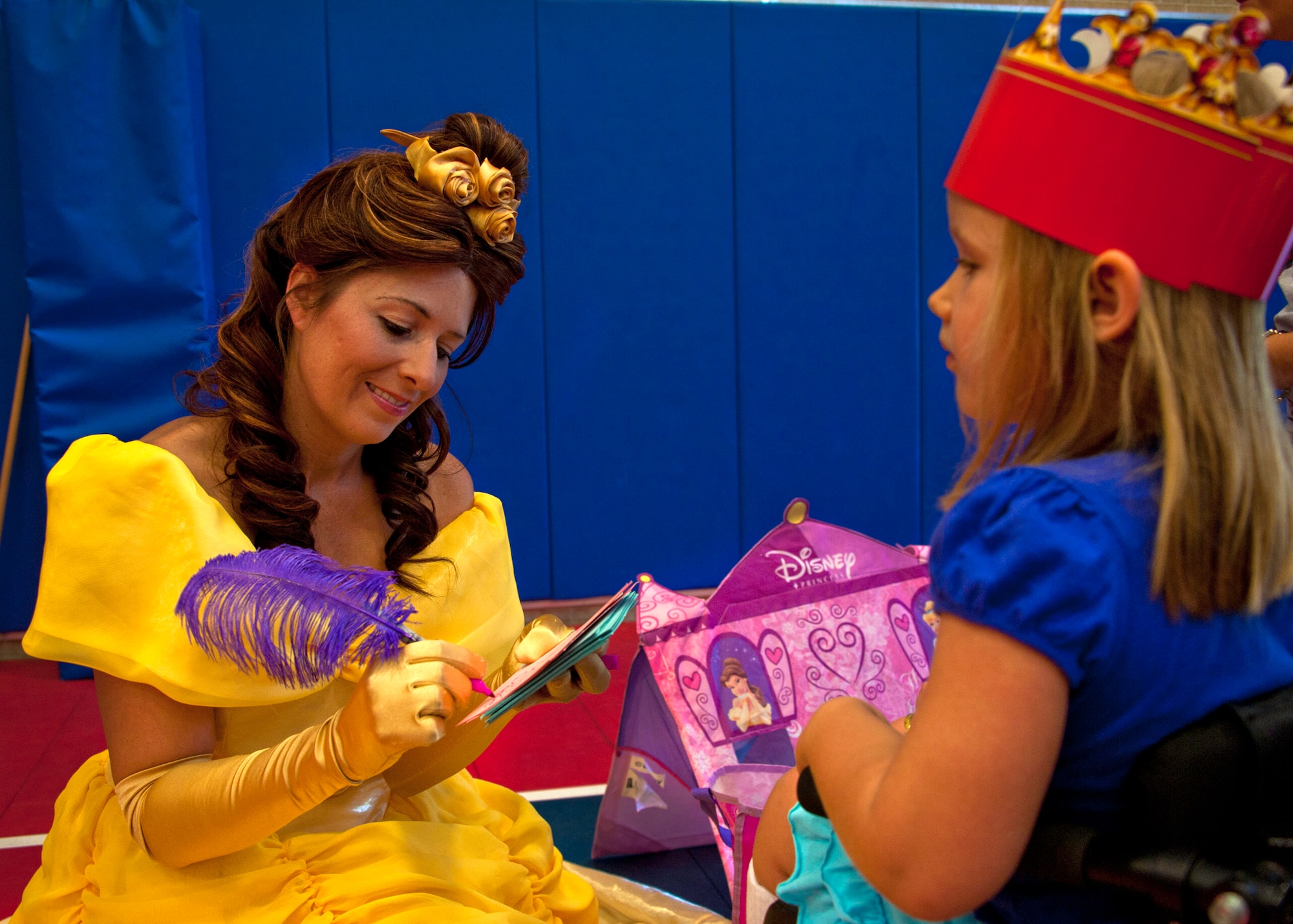 ‘Belle’ signs an autograph for a little princess at the medieval faire at the Eglin youth center July 29.  The “faire” was the culmination of the 2011 “A Midsummer Knight’s Read,” program held by the base library.  More than 180 children, parents, knights and ladies attended. (U.S. Air Force photo/Randy Gon)