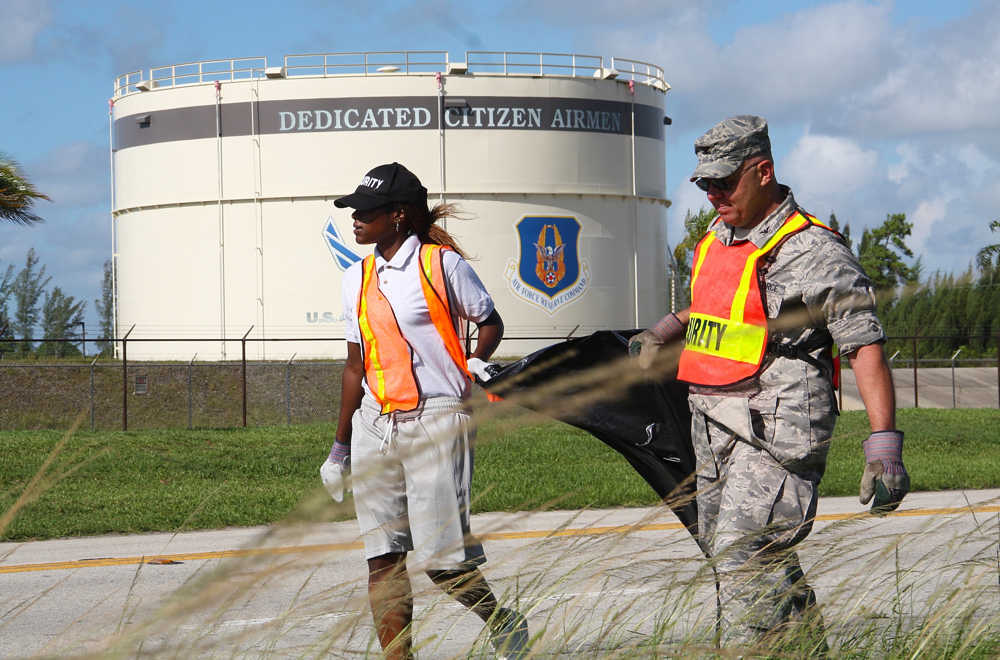 Col. Elwin A. Rozyskie, Jr, Commander,  482nd Mission Support Group walks along Southwest 288th Street with a Job Corps Joint Uniform Military Prep student picking up trash in conjunction with the Job Corps Adopt-a-Road program on July 28. (U.S. Air Force photo by Senior Airman Lou Burton, 482nd Fighter Wing Public Affairs)