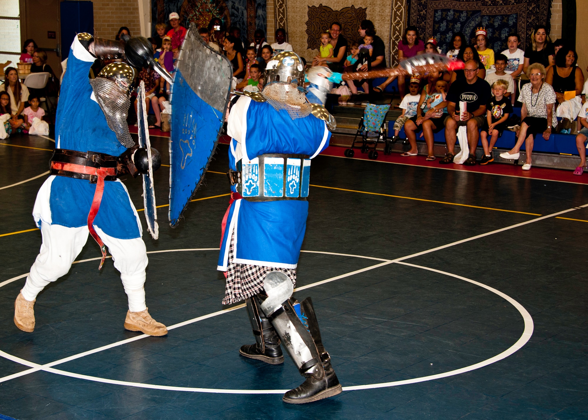 Armored knights, Cody Beard and Mike Heath, battle to the death in front of the children and parents attending the medieval faire at the Eglin youth center July 29.  The medieval faire was the culmination of the 2011 “A Midsummer Knight’s Read,” program held by the base library.  More than 180 children, parents, knights and ladies attended. (U.S. Air Force photo/Randy Gon)