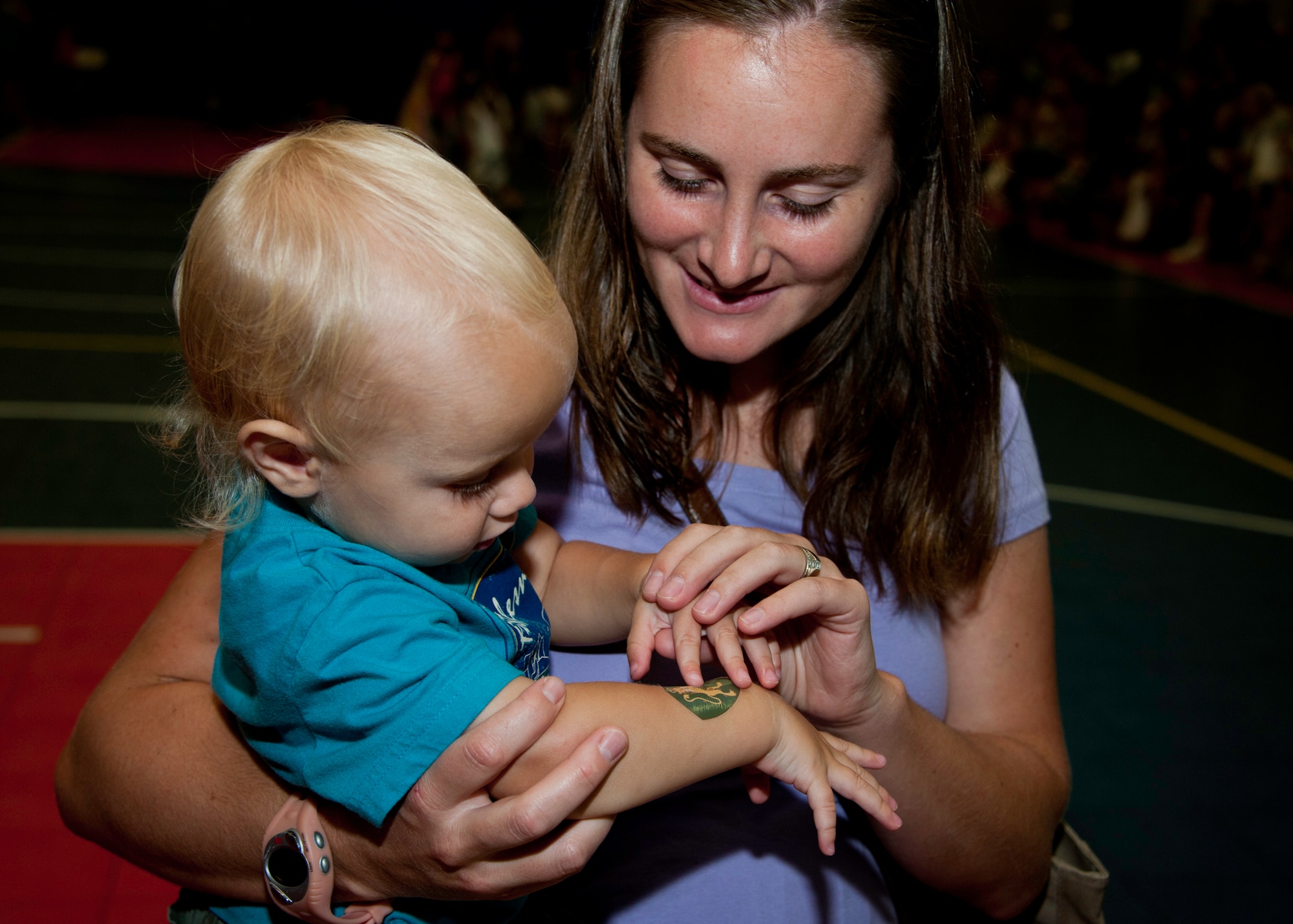 A mother admires her child’s new coat-of-arms tattoo at the medieval faire at the Eglin youth center July 29.  The “faire” was the culmination of the 2011 “A Midsummer Knight’s Read,” program held by the base library.  More than 180 children, parents, knights and ladies attended.  (U.S. Air Force photo/Randy Gon)