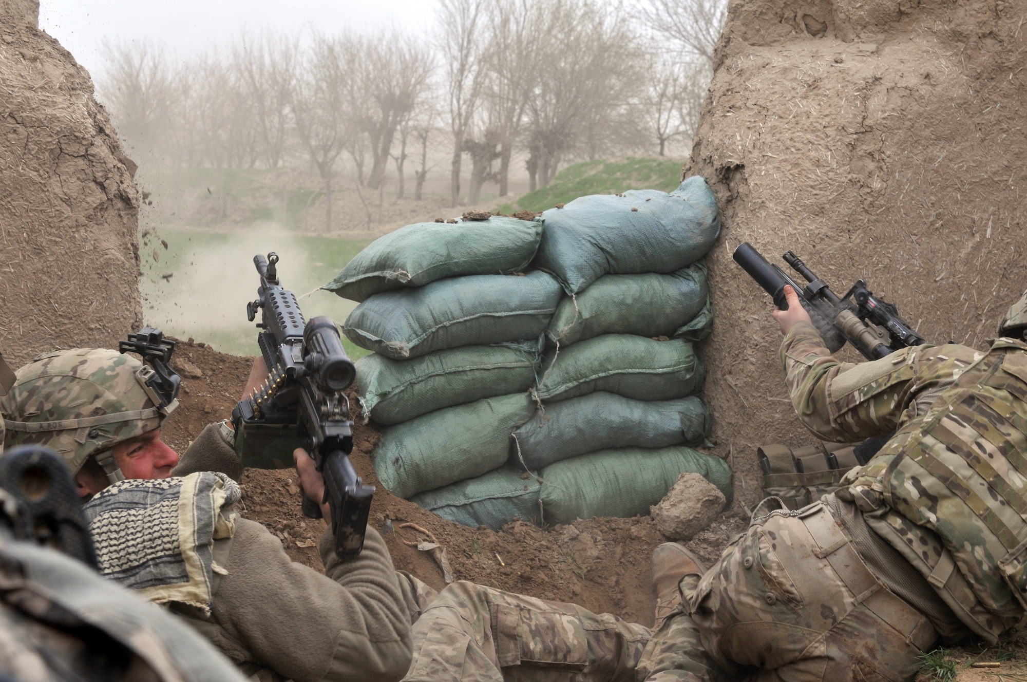 BALA MURGHAB, Afghanistan – U.S. Army Pfc. Ben Bradley (left), a Red Platoon scout (7th Squadron, 10th Cavalry Regiment), ducks away from small-arms fire, as fellow scout Sgt. Jeff Sheppard, launches a grenade at the enemy’s position, during a combat engagement in northern Bala Murghab, Afghanistan April 4, 2011. Bradley, Sheppard, Tech. Sgt. Kevin Wallace, Navy Petty Officer 3rd Class Ryan Lee and his military working dog ‘Valdo’ were all wounded by a rocket propelled grenade blast in the engagement. All service members suffered minor wounds and Valdo was critical, but survived the attack. (U.S. Air Force photo/Tech. Sgt. Kevin Wallace/RELEASED)