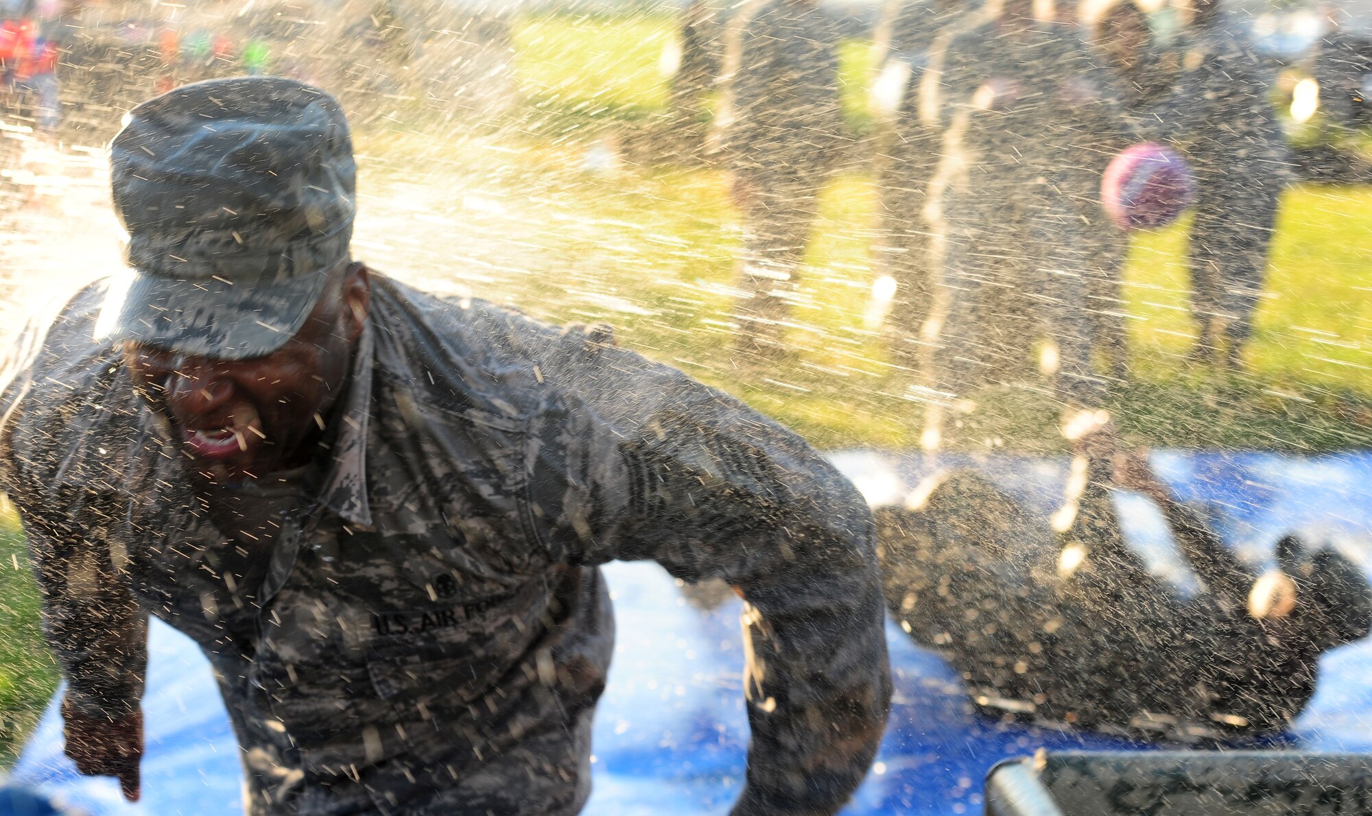 Chief Master Sgt. Derek Crowley, 6th Air Mobility Wing command chief, gets blasted by water as he races through an obstacle course at the Enlisted Combat Dining In, at MacDill Air Force Base, Fla., July 29, 2011. The dining in included enlisted members from all branches of service and was held to boost morale throughout the base. (U.S. Air Force photo by Airman Basic David Tracy)